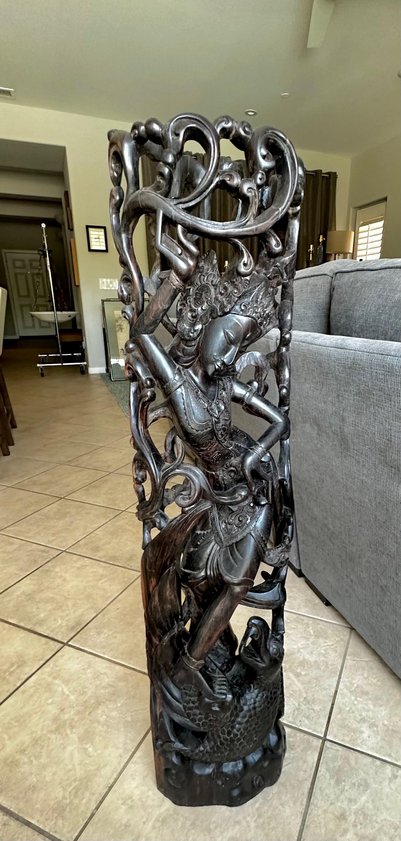 Statua alta e magistralmente scolpita in legno duro dell'Indonesia (o di Bali) raffigurante una divinità indù che danza su un serpente o un demone. La statua pesa più di 30 chili.
(Si consiglia di fissare la statua a una parete o su un supporto
