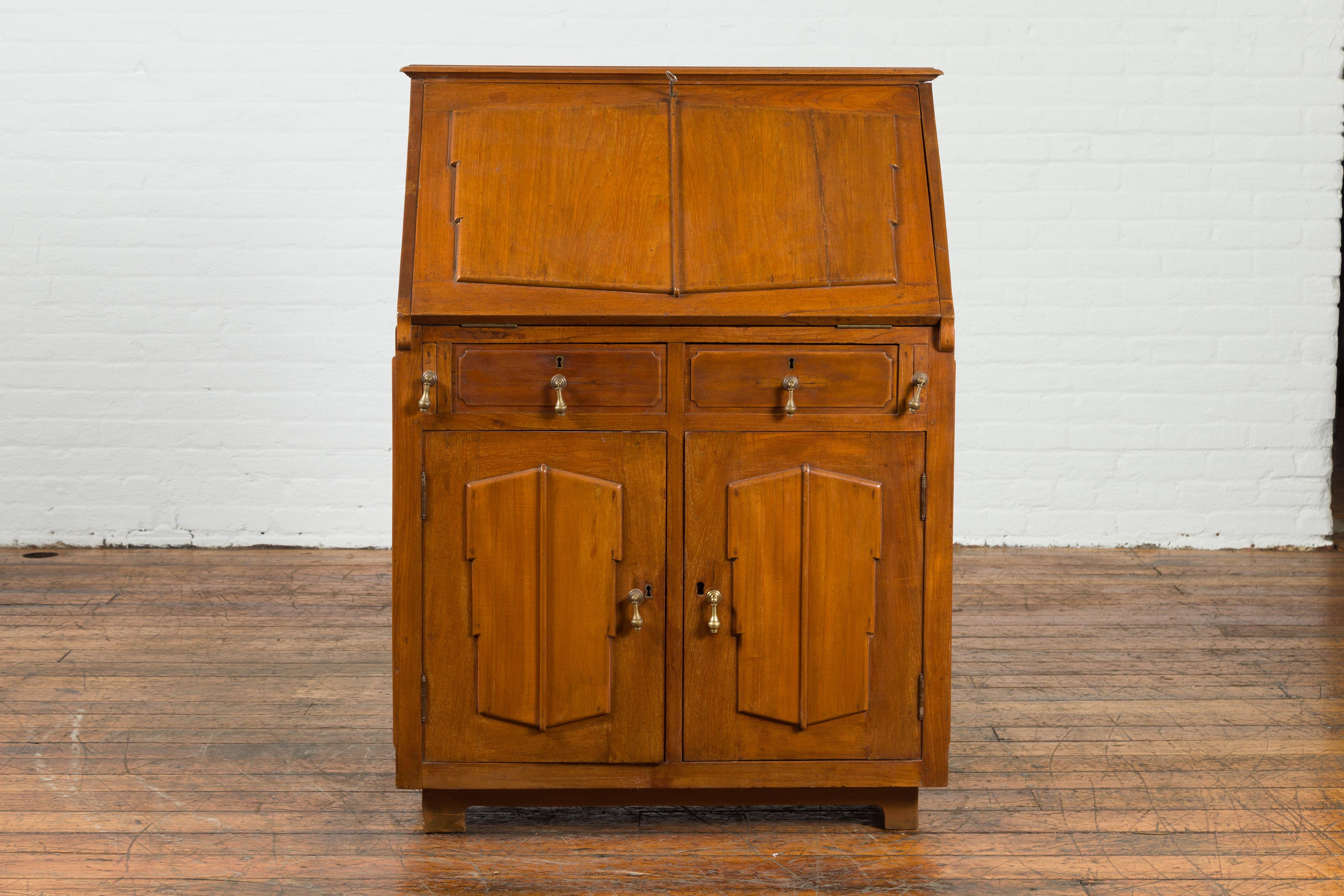 An Indonesian antique handmade slant-front desk from the 19th century, with raised panels and inner drawers. Created in Indonesia during the 19th century, this secretaire features a slant-front desk with raised panels, opening to reveal two drawers