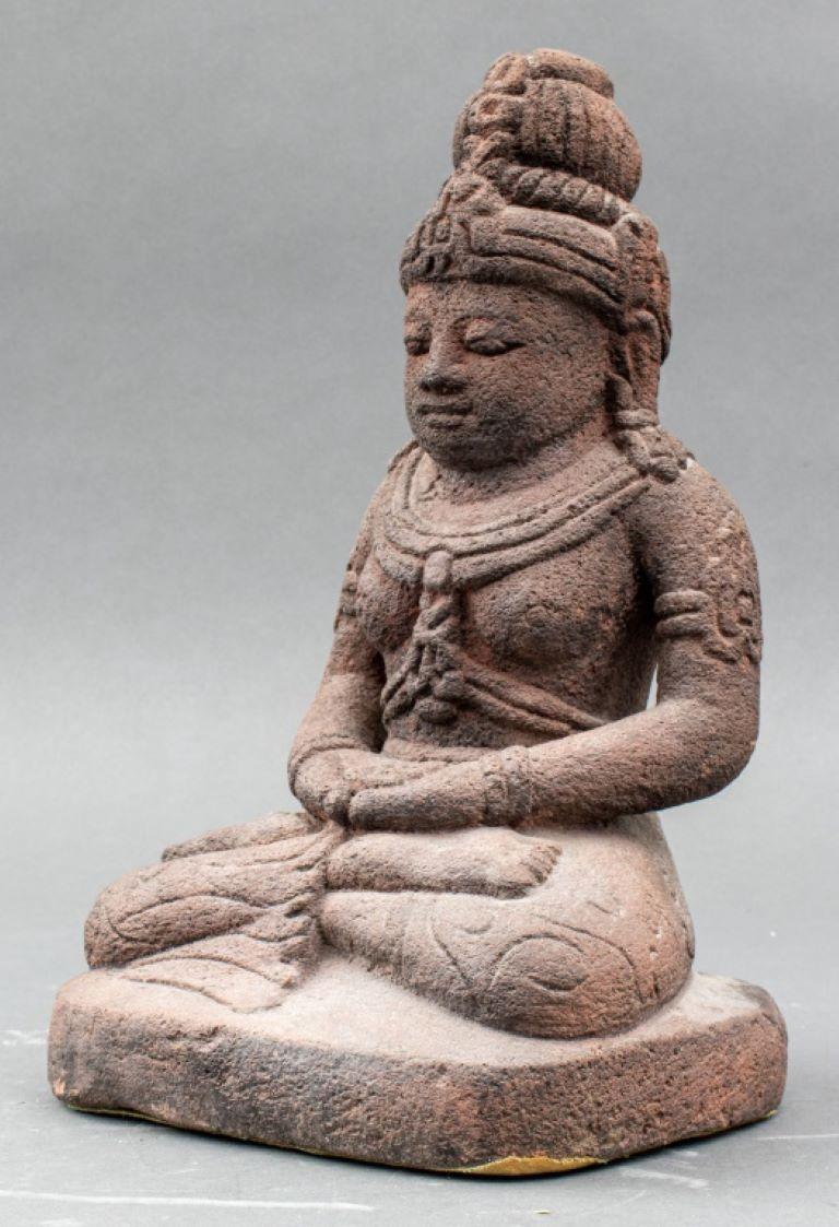 Indonesian andesite figure depicting a seated bodhisattva in lotus position / padmasana wearing armbands, earrings, bracelets, necklaces, pants with carved scrolling design, and a headdress, Java, 16th century or later.

Dealer: S138XX