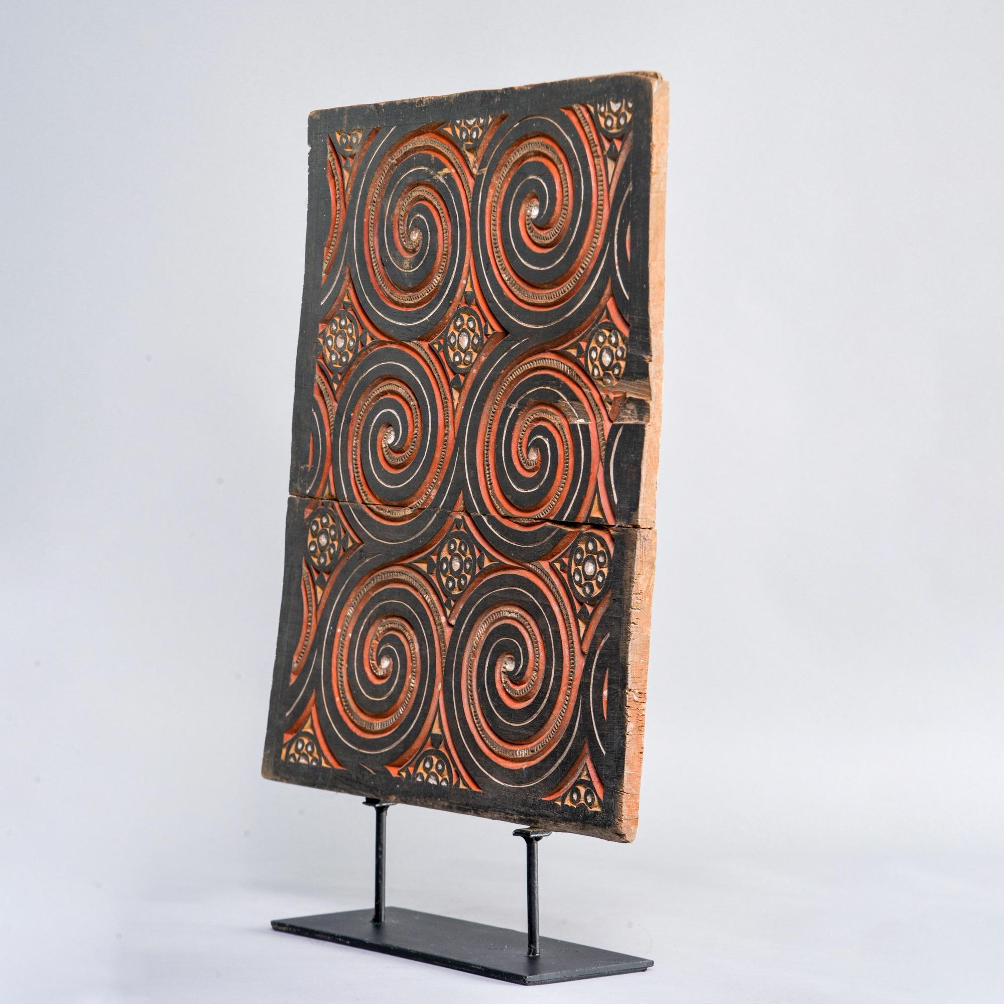 Circa 1930s carved and painted Indonesian wooden panel on black iron display stand. 