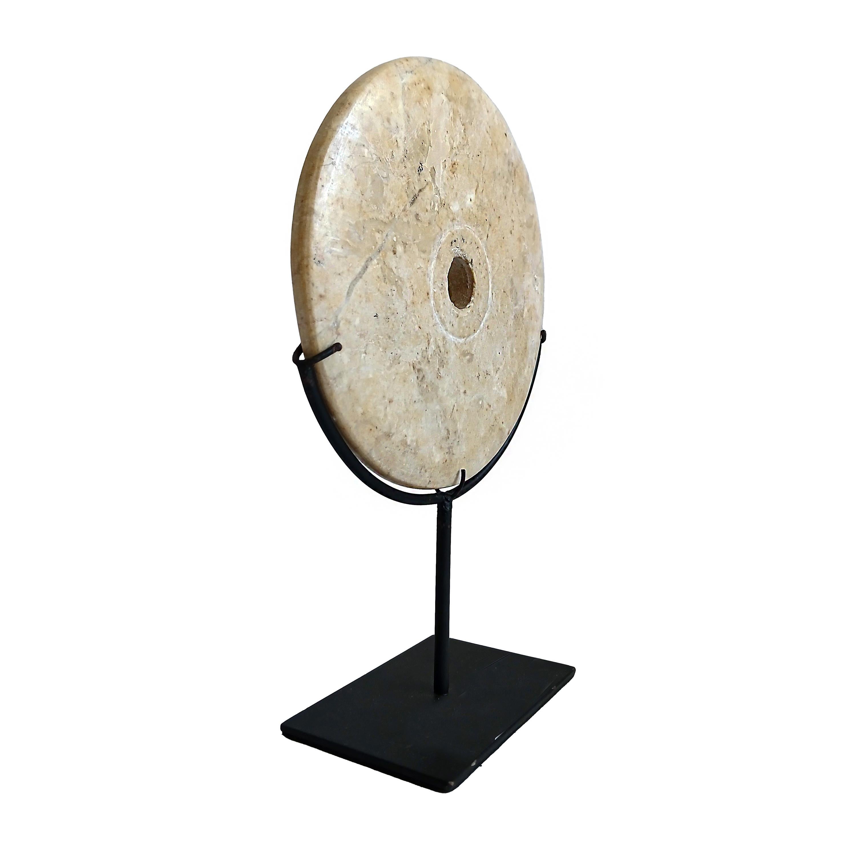 A yellow marble disk, hand-carved in Indonesia, contemporary. 

Reminiscent of the traditional 