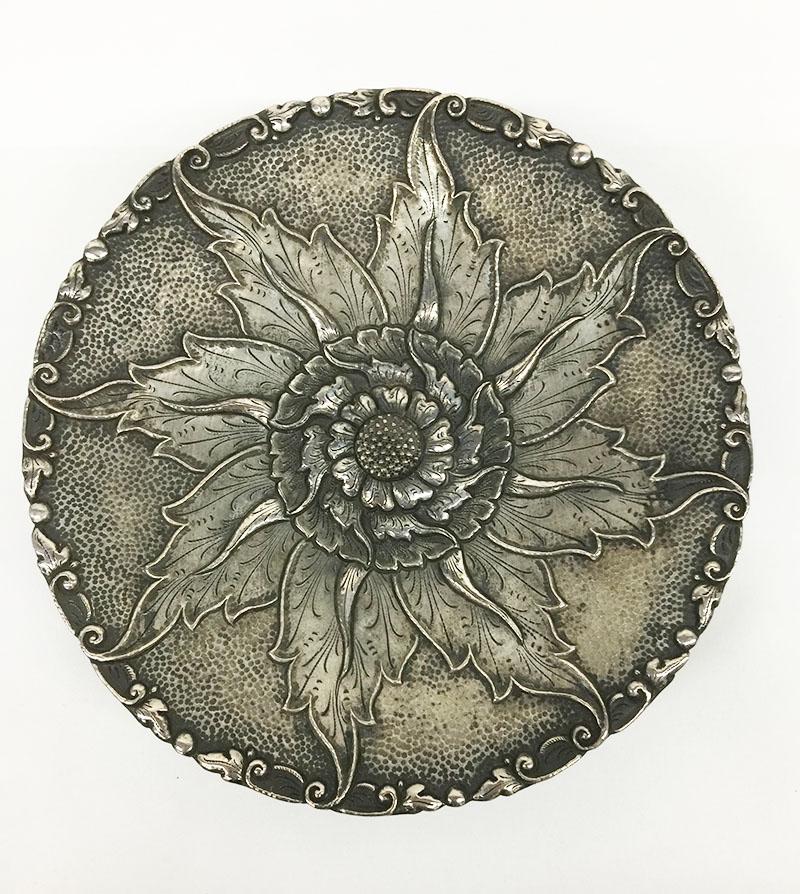 Indonesian silver Yogya 3-legged dish with floral pattern

Marked with S800 
On the edge a small scene of leaves and in the middle a flower in relief
partly hammered raised on smooth 3 legs under the base 
Yogya is known that the silver may not be