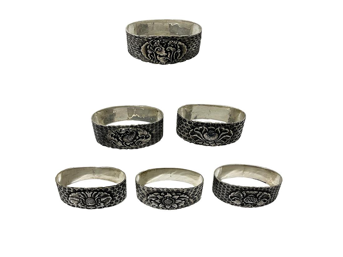 Indonesian Silver Yogya Napkin Rings, 1930s

Six Yogya silver napkin rings, made in Indonesia, 1930s. Each napkin ring has a flower decor in the center and surrounded with different floral patterns impressed in the silver. Two of the rings have the