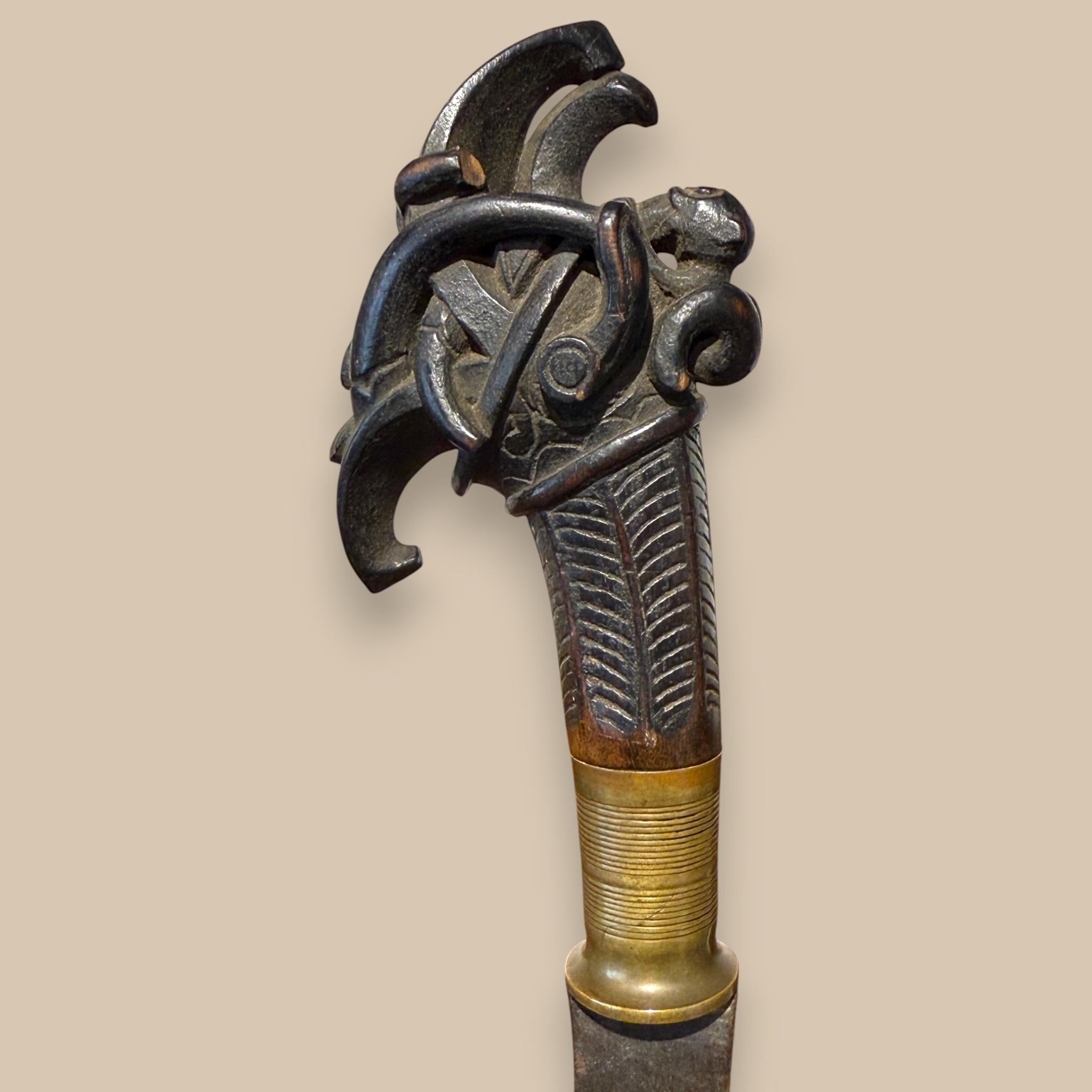 Metallo Indonesian Single-Edged Sword with Carved Wooden Hilt, 19th Century in vendita