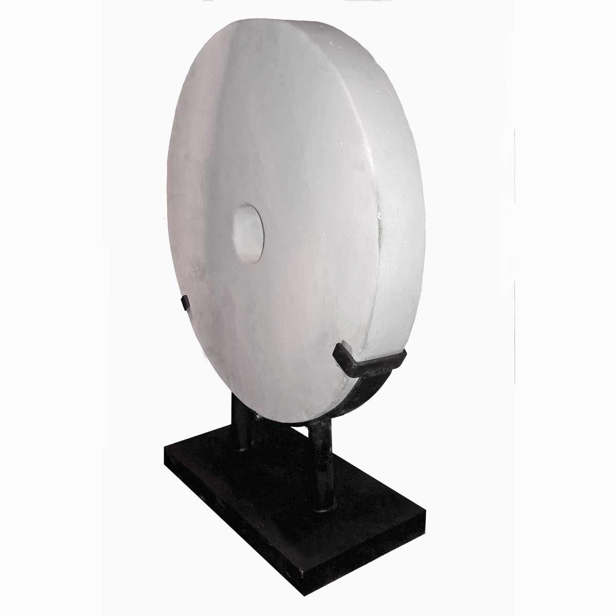 A white stone wheel from Indonesia. Mounted in a black metal stand. Its clean, simple lines make this stone coin a great accent to a minimalist decor.
