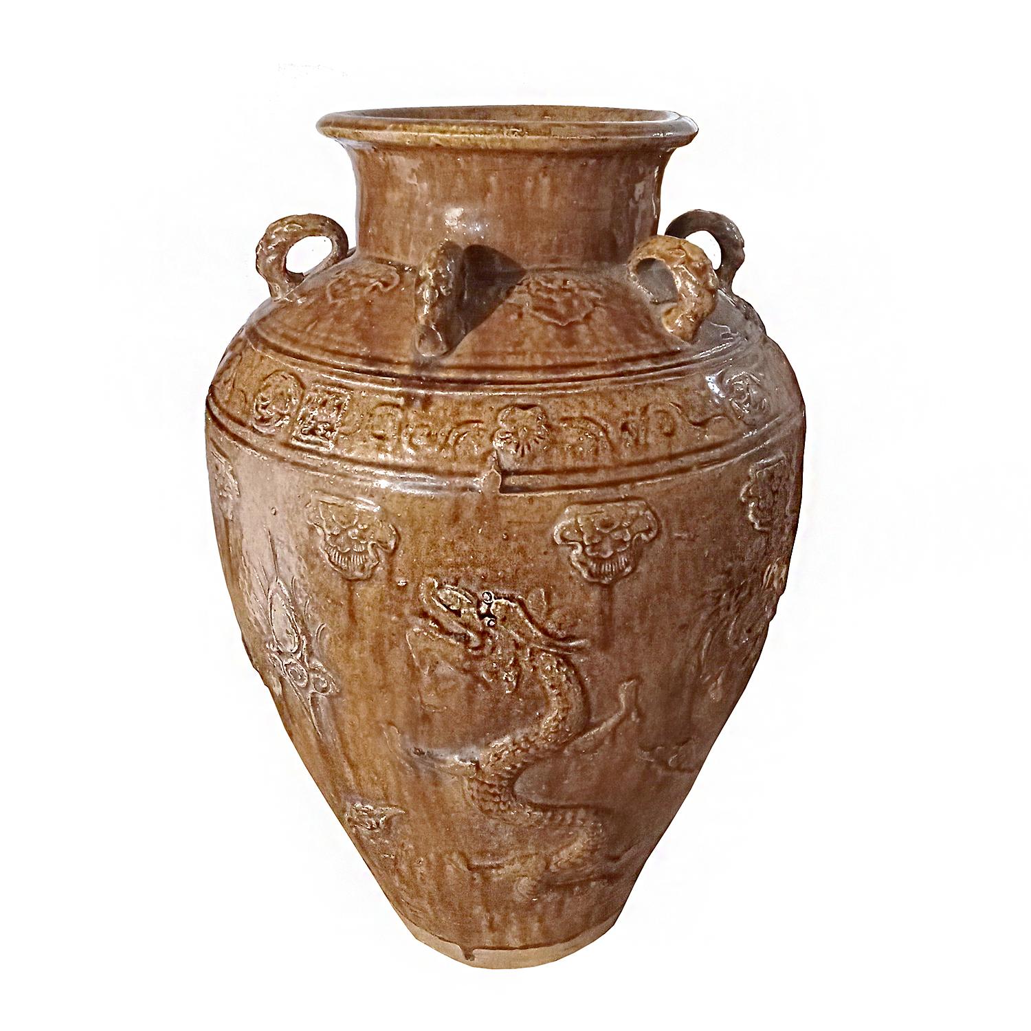 A large ceramic jar / vase / urn from Bali, Indonesia, late 20th Century, hand-crafted. Three Decorative handles, glossy brown glaze, and bas-relief throughout with classic Asian dragon design. 

Can be used indoors or outdoors. 
