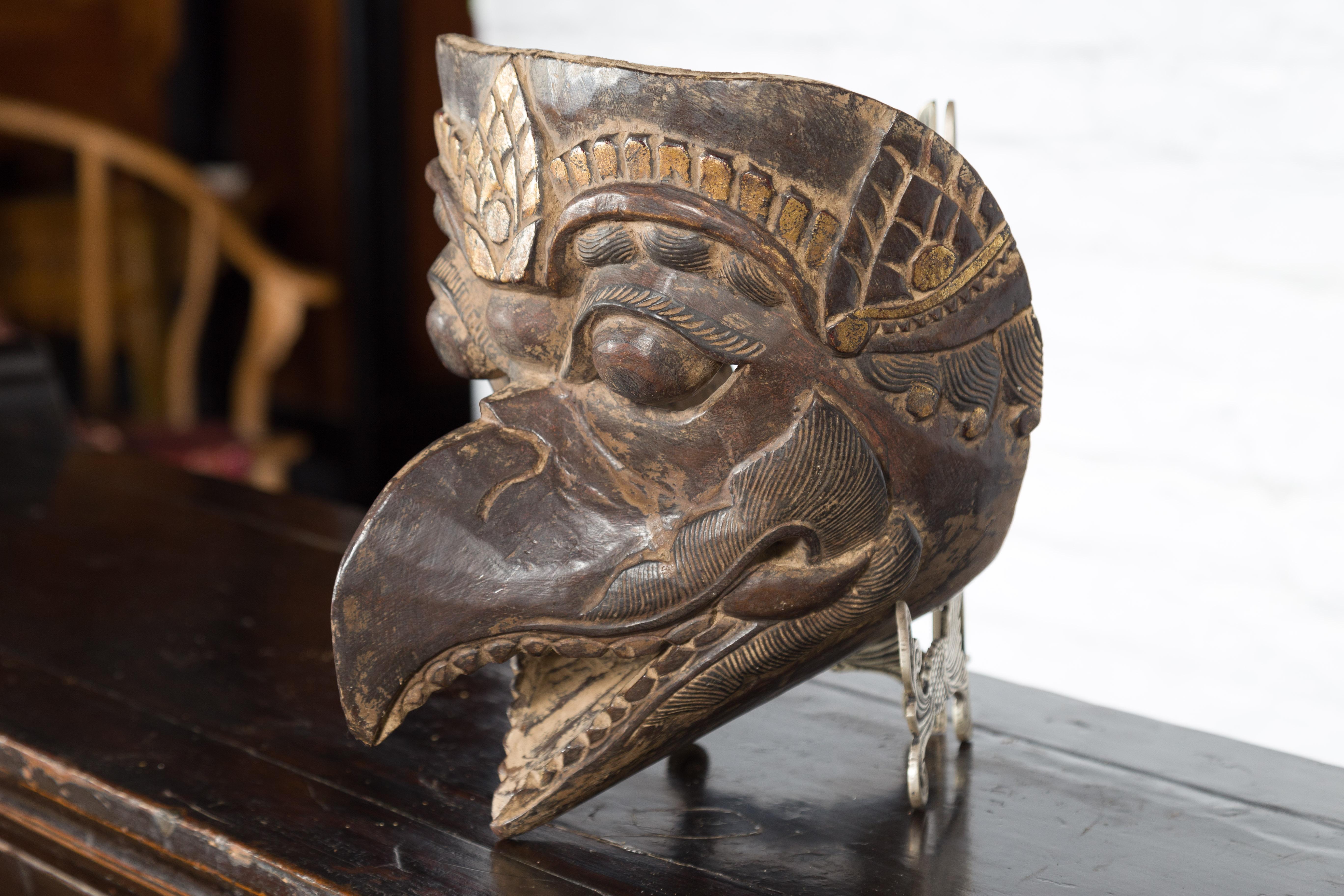 An Indonesian tribal carved wooden mythical animal mask from the island of Lombok located East of Bali and Java. Hand-crafted on the island of Lombok, this wooden mask captures our immediate attention with its striking features a nice patina.