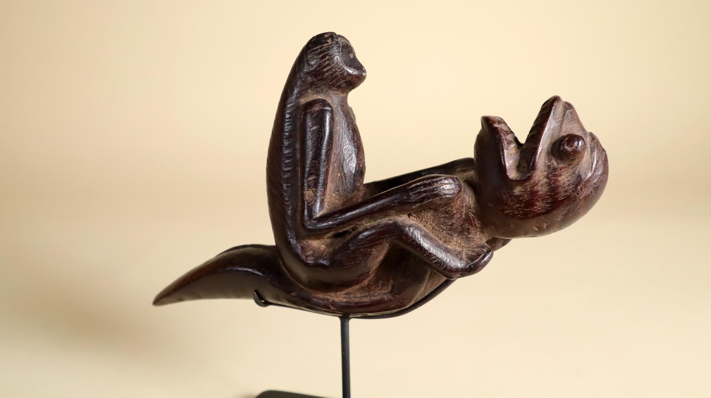 A whimsical and unique carved wood pipe from Indonesia, probably Sumatra, 20th century. A fantastical image of a monkey riding on the belly of a sea monster! Carved from a very hardwood with a black patina from handling.
Comes with a custom metal