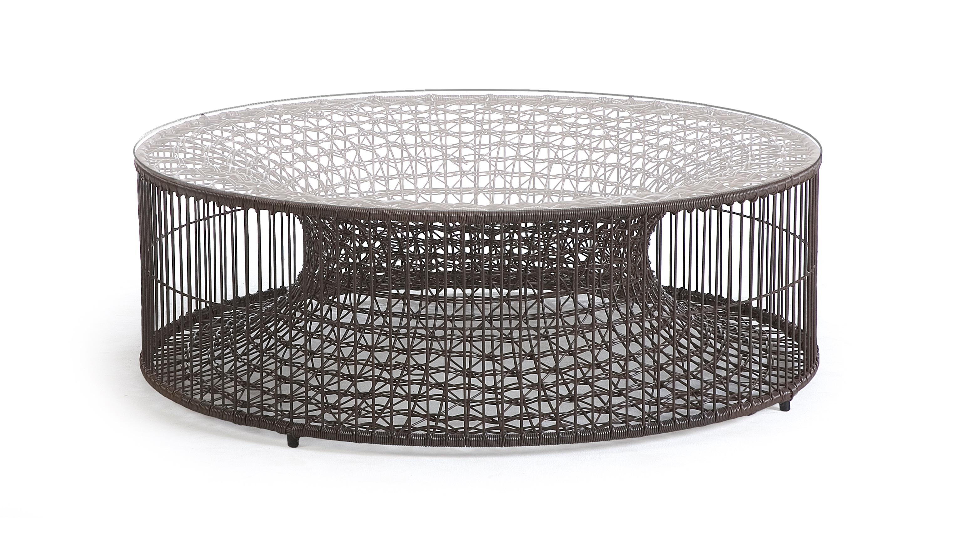 Amaya coffee table by Kenneth Cobonpue.
Materials: abacca. steel. glass.
Dimensions: diameter 102 cm x height 34 cm.

Inspired by fish traps, the Amaya tables resemble a vortex enclosed within a cylinder. While the indoor version is crafted with