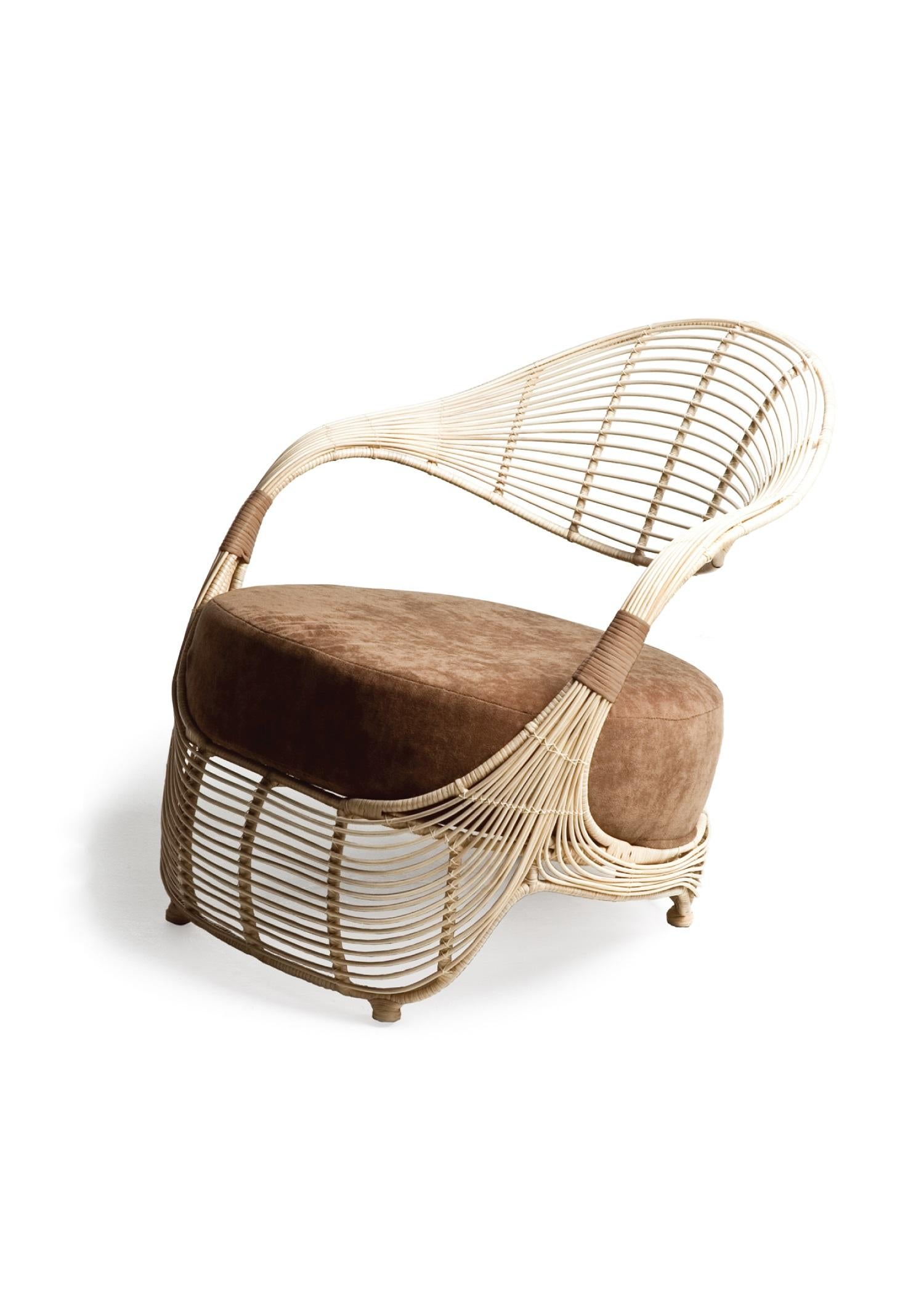 Indoor manolo easy Armchair by Kenneth Cobonpue
Materials: Rattan, nylon, steel. 
Also available in other colors and for outdoors.
Dimensions: 80.5 cm x 70.5 cm x H 73 cm

Taking inspiration from the curves of a woman’s sandal, Manolo’s playful