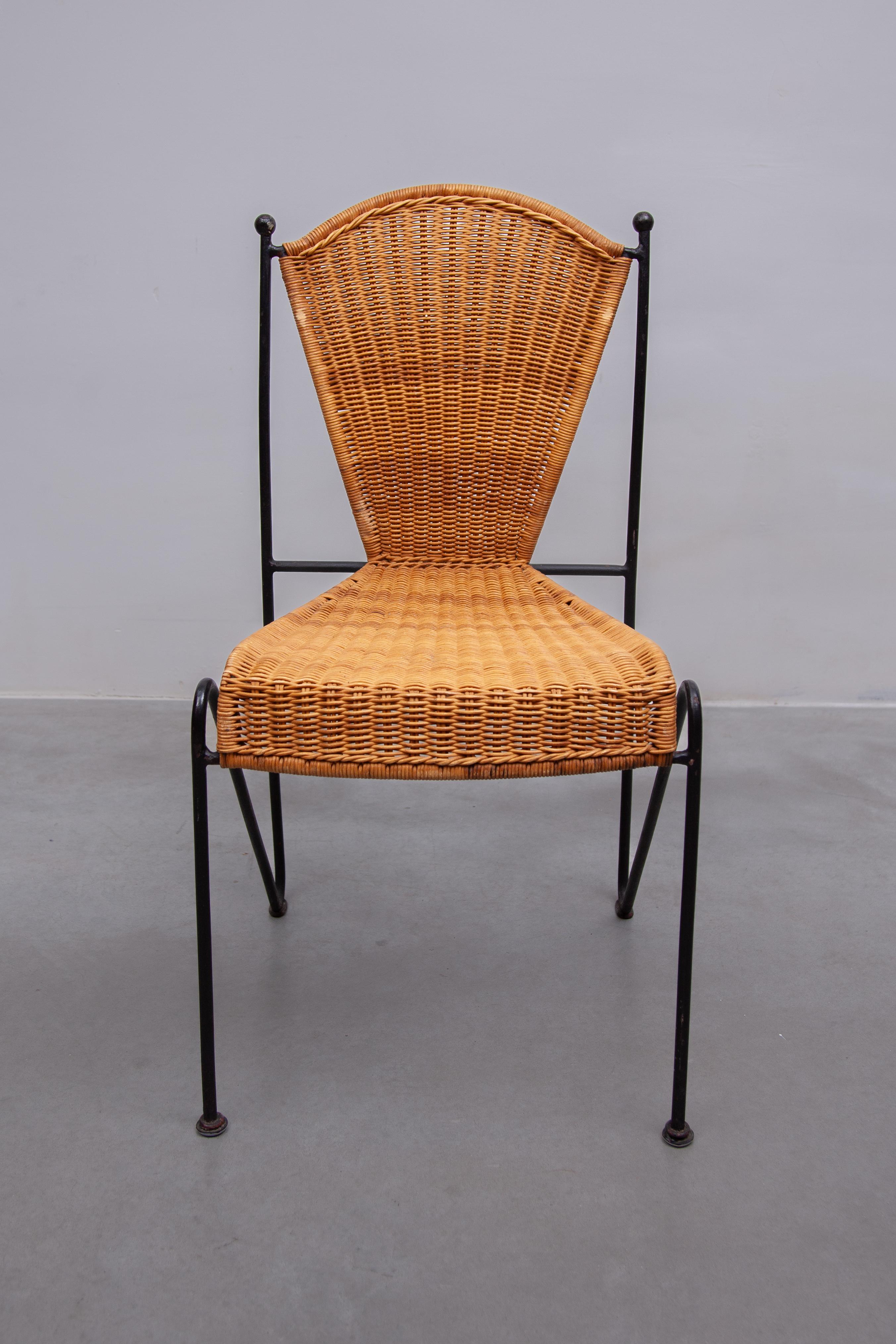 Set di sedie da pranzo vintage per interni ed esterni disegnate da Pipsan Saarinen Swanson per Ficks Reed. Scultorei telai in ferro nero con terminali a sfera neri. Sedute in rattan intrecciato. Set di quattro sedie. Dimensioni: 44L x 85H x 44D cm.