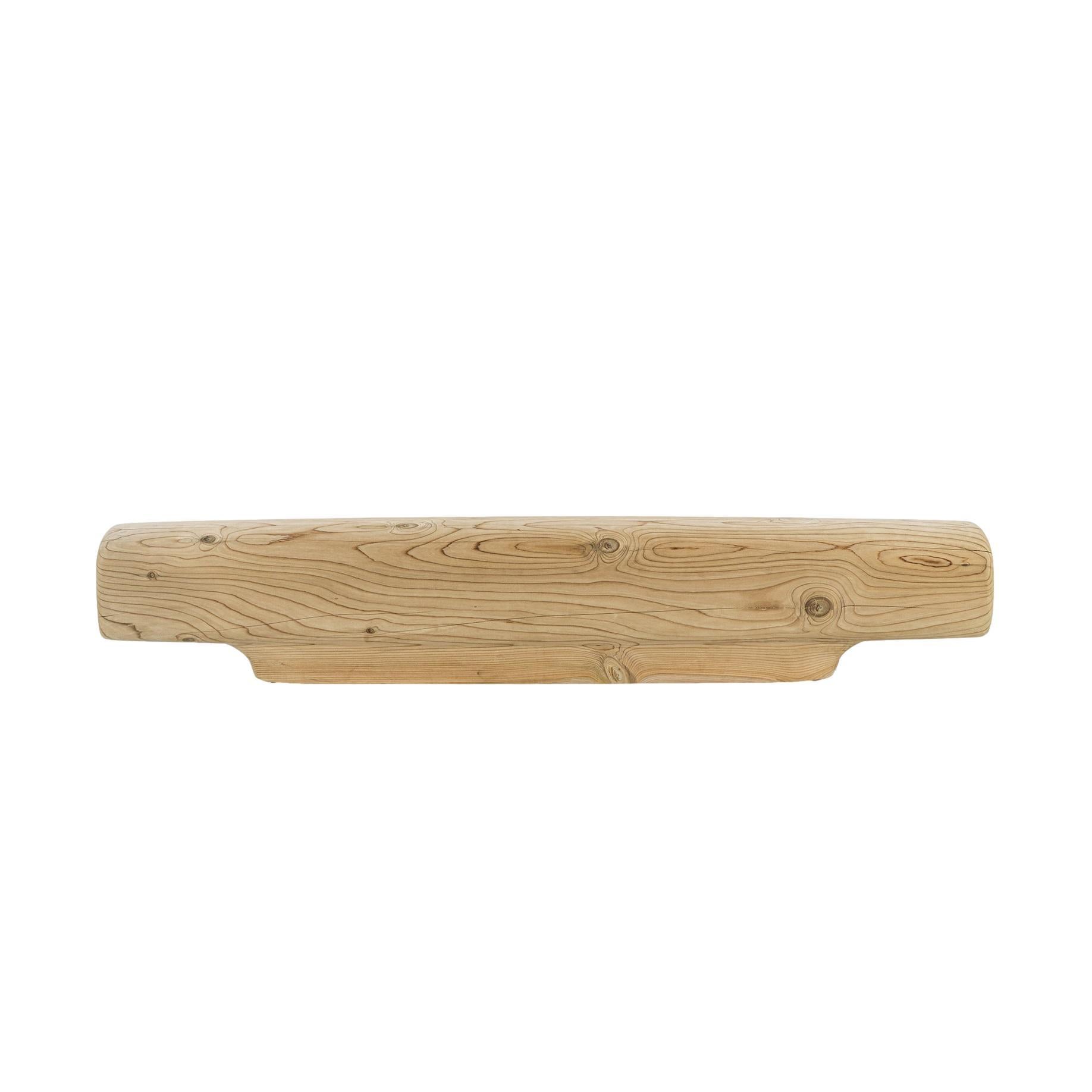 Questa panchina è ricavata da un unico blocco di cedro massiccio profumato, con una forma allungata e lineare che ricorda una trave di equilibrio. Due generose nicchie ricavate nelle estremità servono come vani per riporre libri, riviste o tessuti,