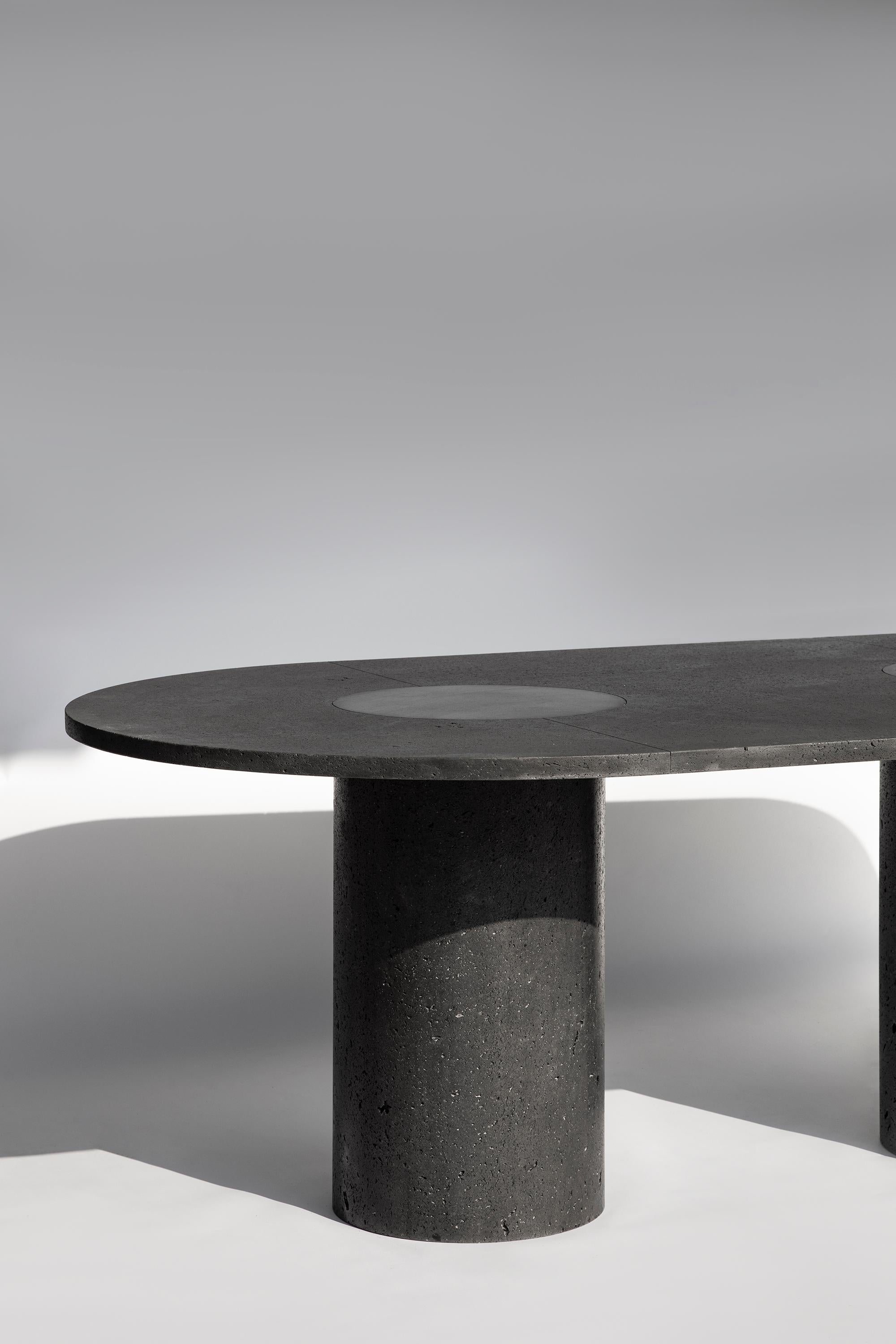 In Peca's indoor/outdoor PETRA dining table, a rich, porous top sits atop three cylindrical monoliths, born from the whims of Mexico's volcanic terrain. Etched lines run through the surface of PETRA's top, guiding the eye towards three soft and