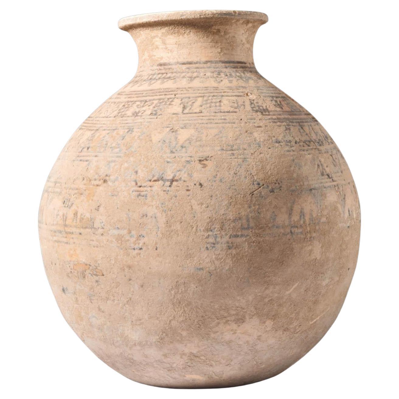 Ca. 2500 A.C. Un grande vaso in terracotta, dalla forma distintiva caratterizzata da una base piatta, un corpo principale bulboso che si assottiglia con grazia verso il collo e culmina in un bordo pronunciato. La sua eleganza strutturale è una