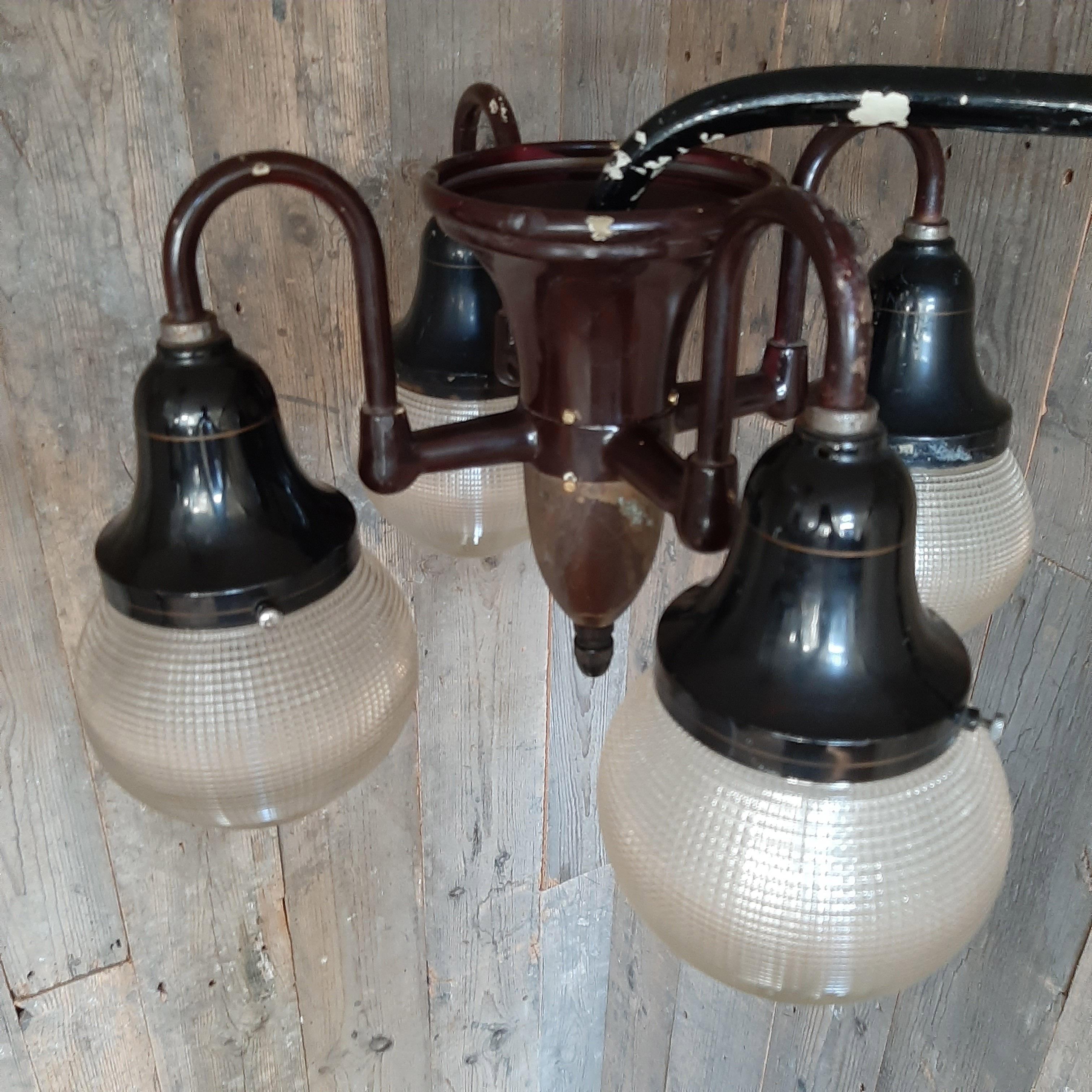 Vintage 1930s Holophane dentist overhead light. Industrial pendant lamp with a black steel body, four arms and four acorn shades. The lamp is fitted on a movable steel arm.

Measurements lamp: 35 x Ø 49 cm
Measurements arm: 35 x 60 cm.