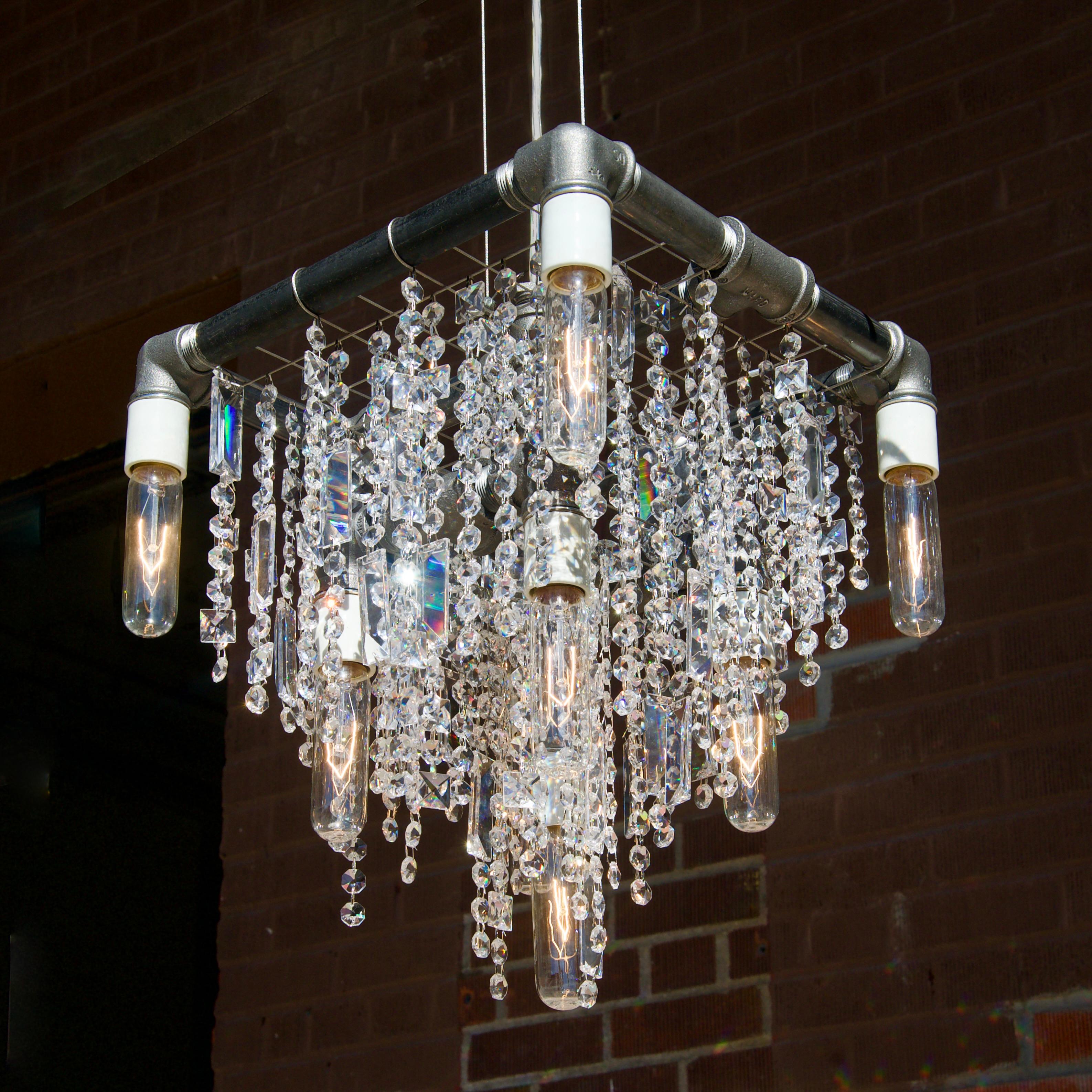 The industrial 9-bulb compact Beacon pendant chandelier is the newest model in our Industrial Collection and one of the most spectacular. At first glance it appears to be a traditional 3-tiered chandelier, though the sparkle will alert you to the