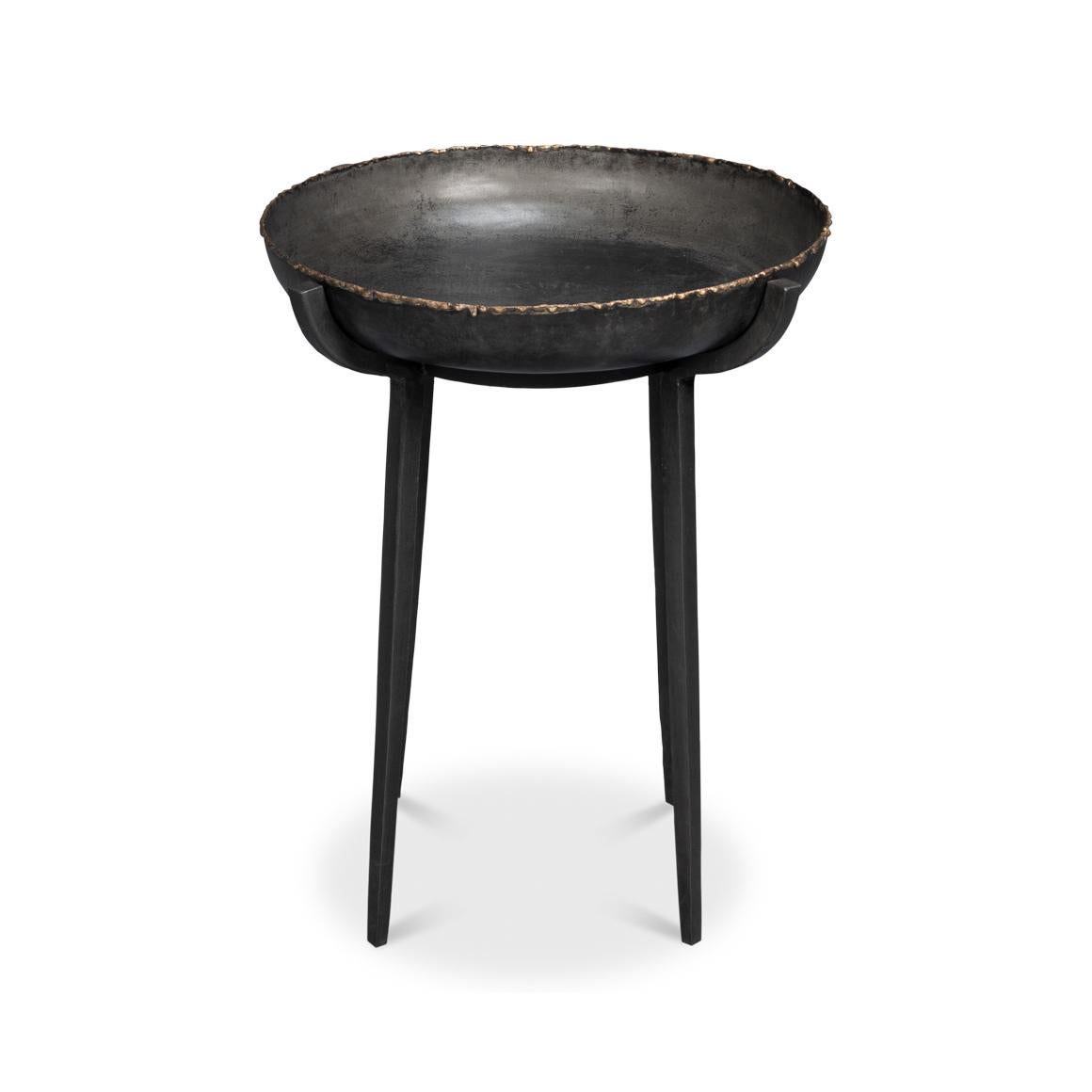 Fabriquée en métal avec une finition noire, le design robuste de cette table incarne l'essence du style industriel.

Le plateau de table en forme de bol, avec ses bords usés, offre une présence sculpturale audacieuse tout en offrant une