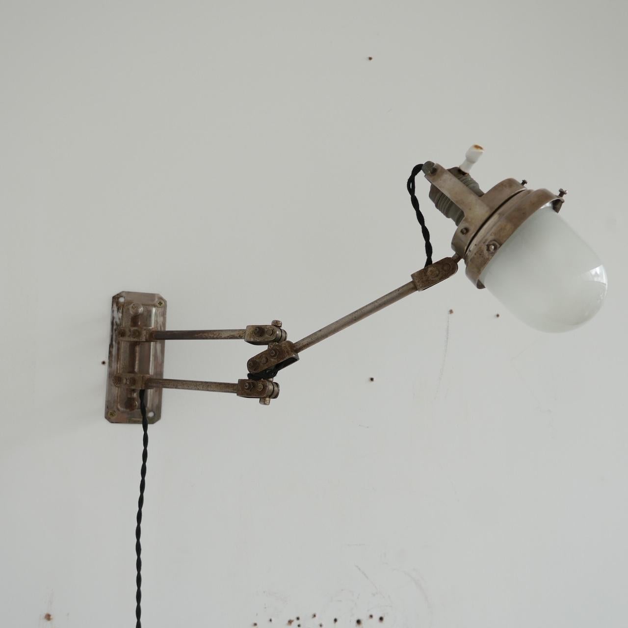 A scarce industrial antique wall light. 

Adjustable in many ways so highly functional as well as aesthetically pleasing.

Likely nickel plated brass, and original etched glass shade has been retained. 

France, c1930s. 

Apparently by Vice