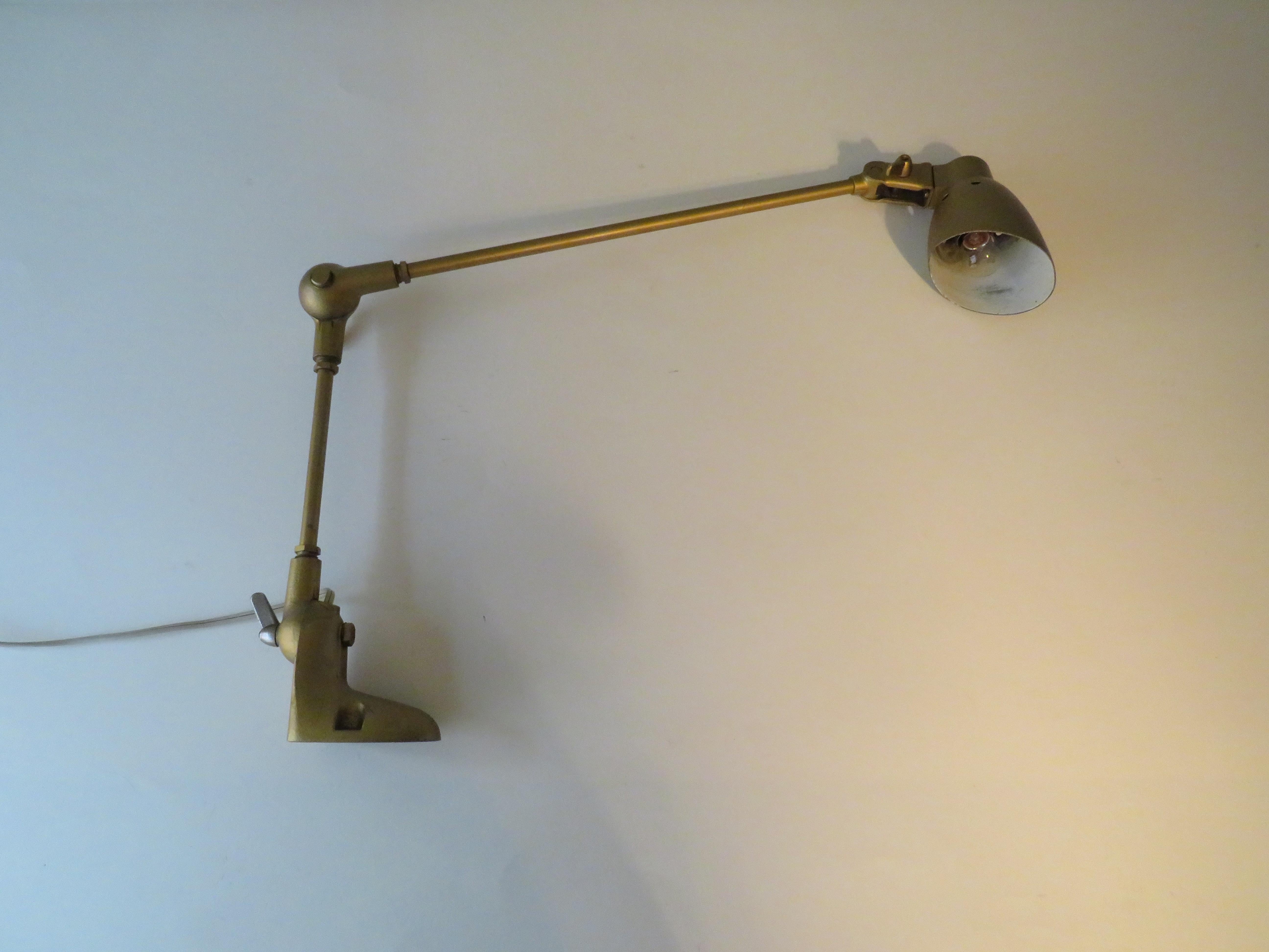 Industrial lamp by Pfaff, sewing machine manufacturer Germany 1950.
The metal lamp is in a hammered gold-colored version, has 2 adjustable arms and the shade can also be positioned in different positions. The lamp can be mounted on a worktop or