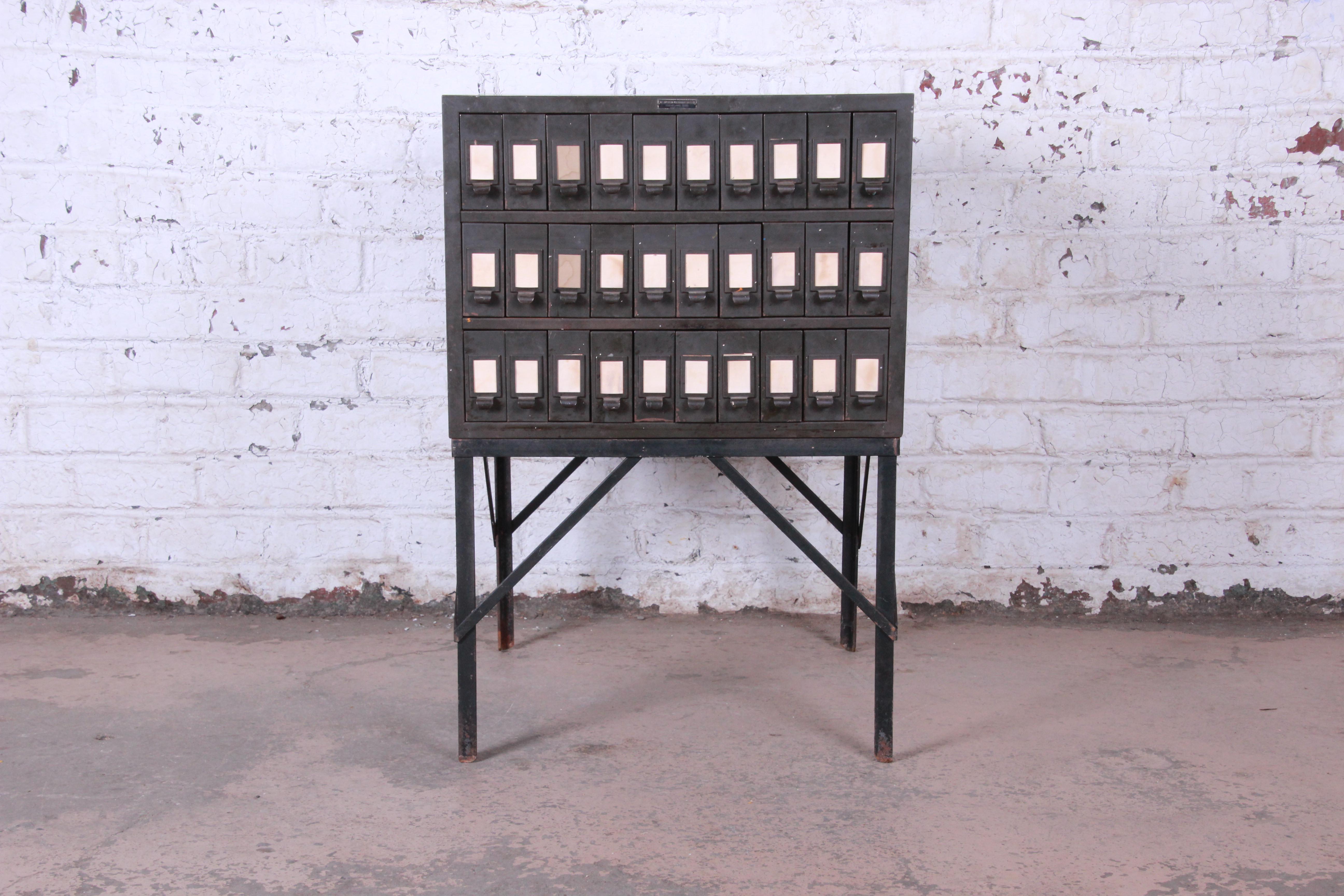 A rare and unique Industrial age 30-drawer parts cabinet or card catalog. The all-metal army green cabinet is heavy and well made in the USA by The American Multigraph Sales Co. of Cleveland, OH. It offers ample storage with 30 drawers. The interior