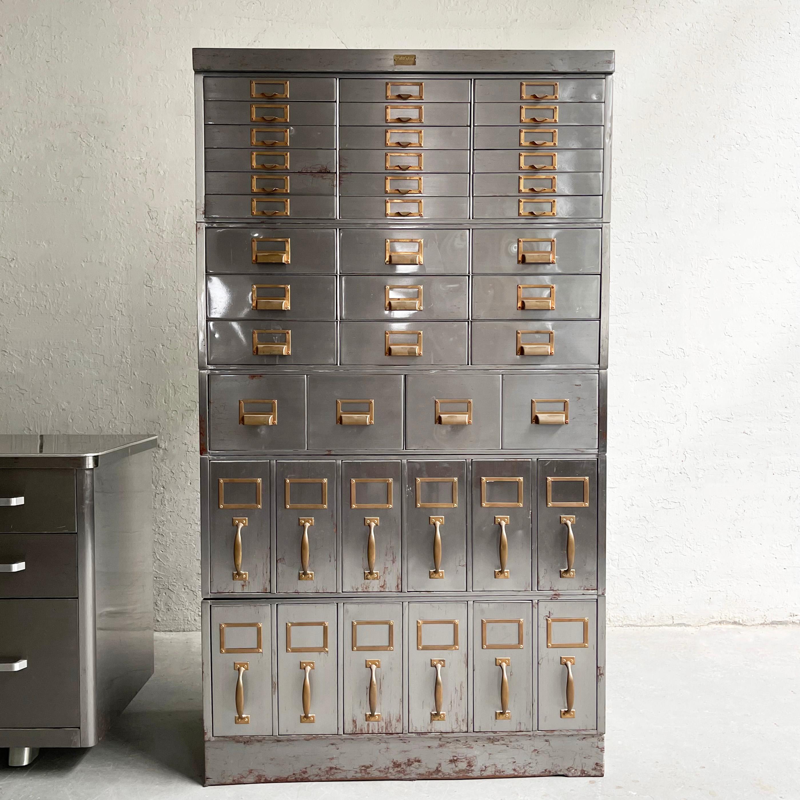 Midcentury, industrial, brushed steel, modular filing cabinet by Allsteel features multiple various sized drawers measuring from top: 10 x 1.75, 10 x 3.5, 8 x 6.25, 5 x 11 inches. The cabinet consists of 7 interlocking modular pieces.