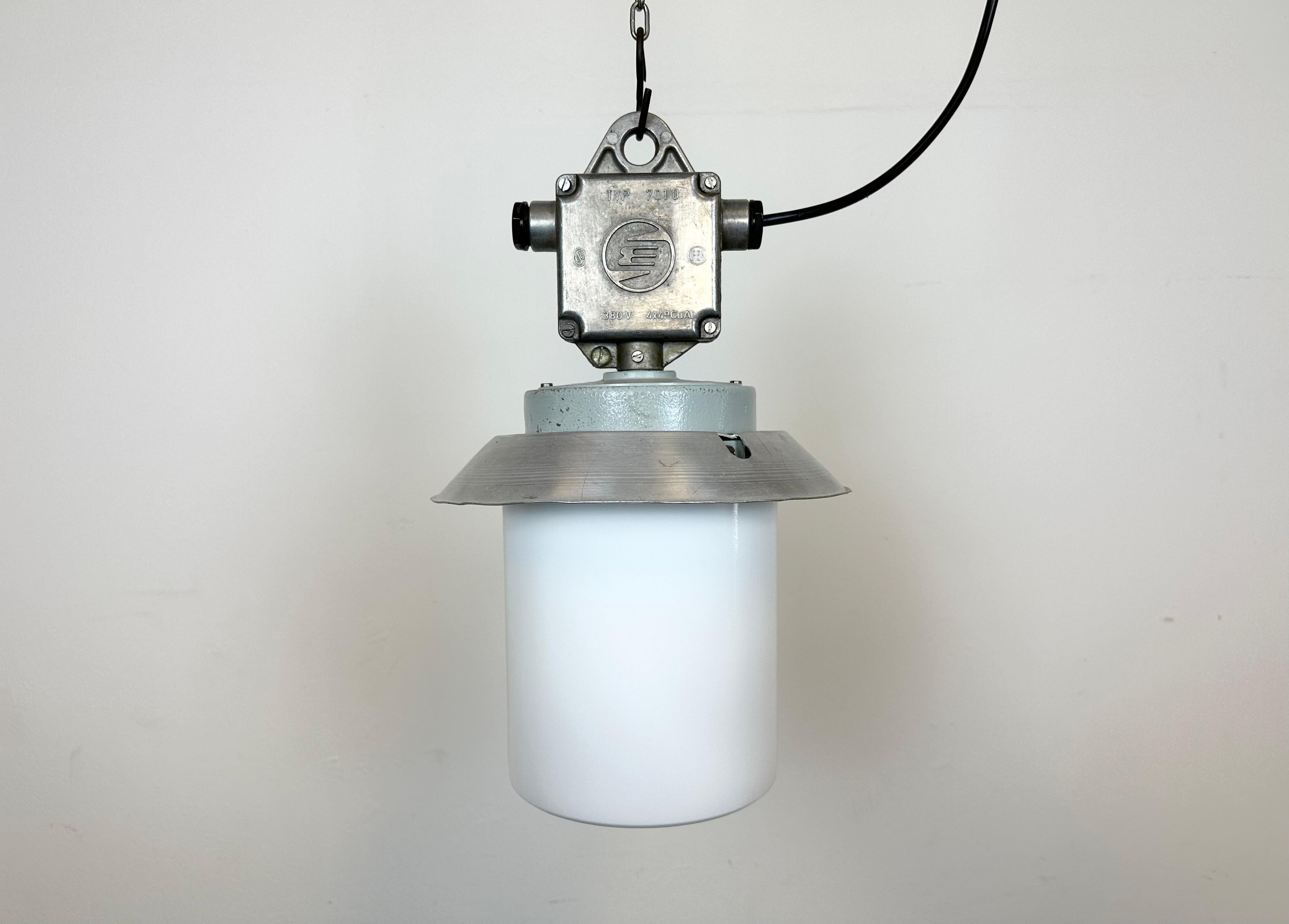 This Industrial hanging light was made by Elektrosvit in former Czechoslovakia during the 1970s. It features a cast aluminium top, an aluminium shade and a clear glass cover. New porcelain socket requires standard E 27/ E26 light bulbs. New wire.