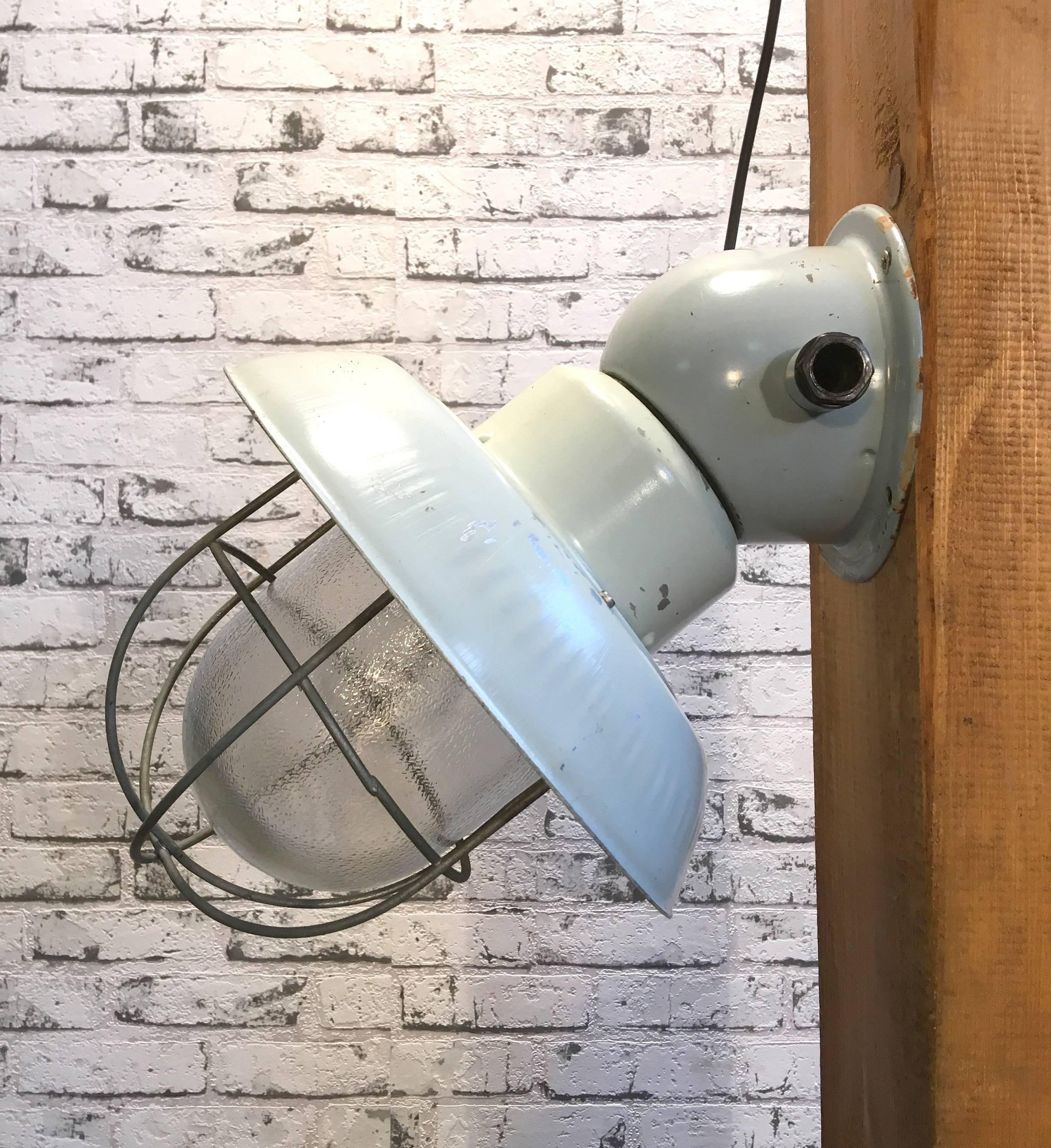 Industrial wall lamp. Aluminium shade, iron top, clear glass. Iron grid.
New porcelain socket E 27.New wire.
Weight: 3.0 kg.