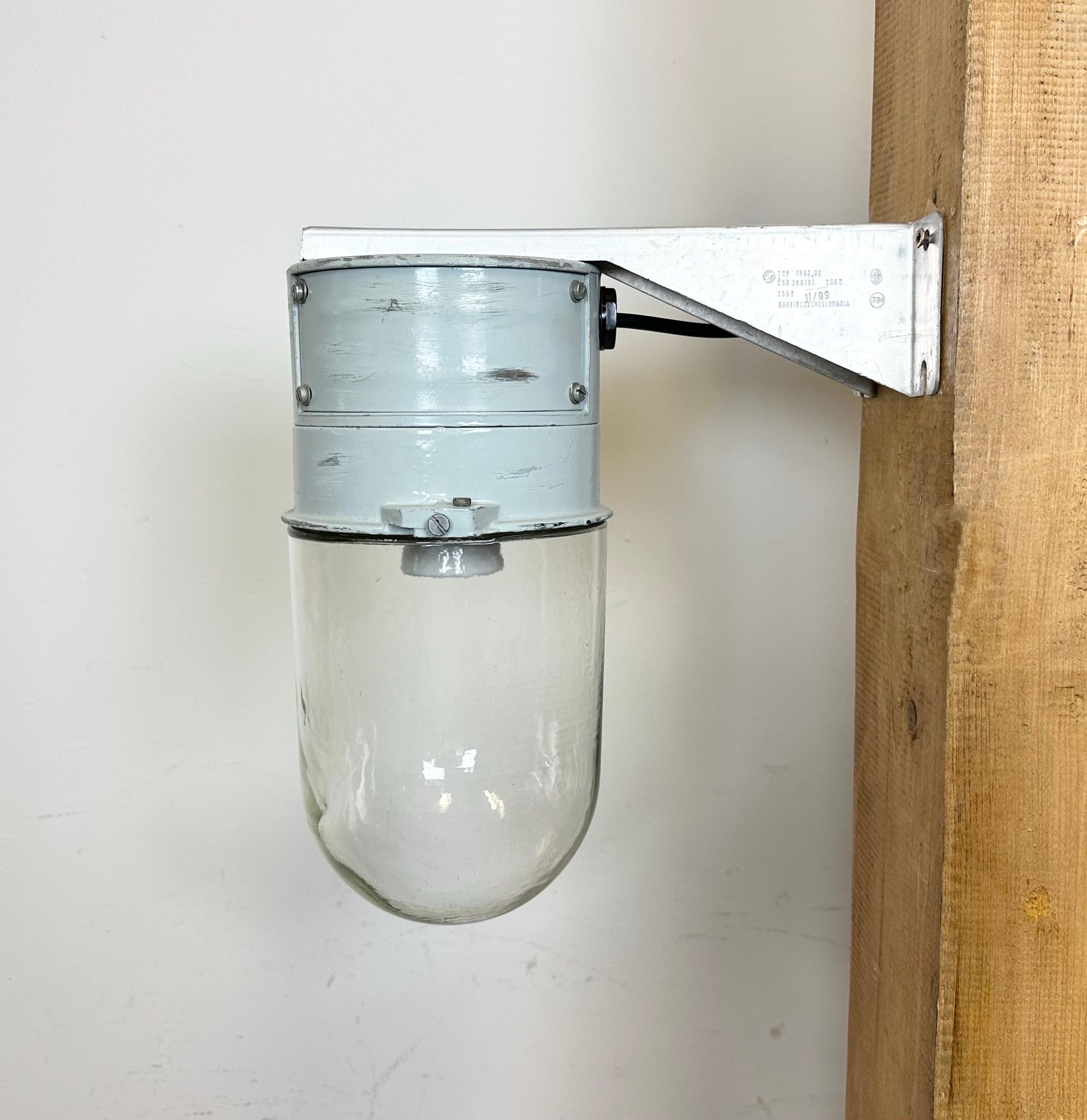 This Industrial wall light was made by Elektrosvit in former Czechoslovakia during the 1970s. It features a cast aluminium wall mounting and a clear glass cover. New porcelain socket requires standard E 27/ E26 light bulbs. New wire. The weight of