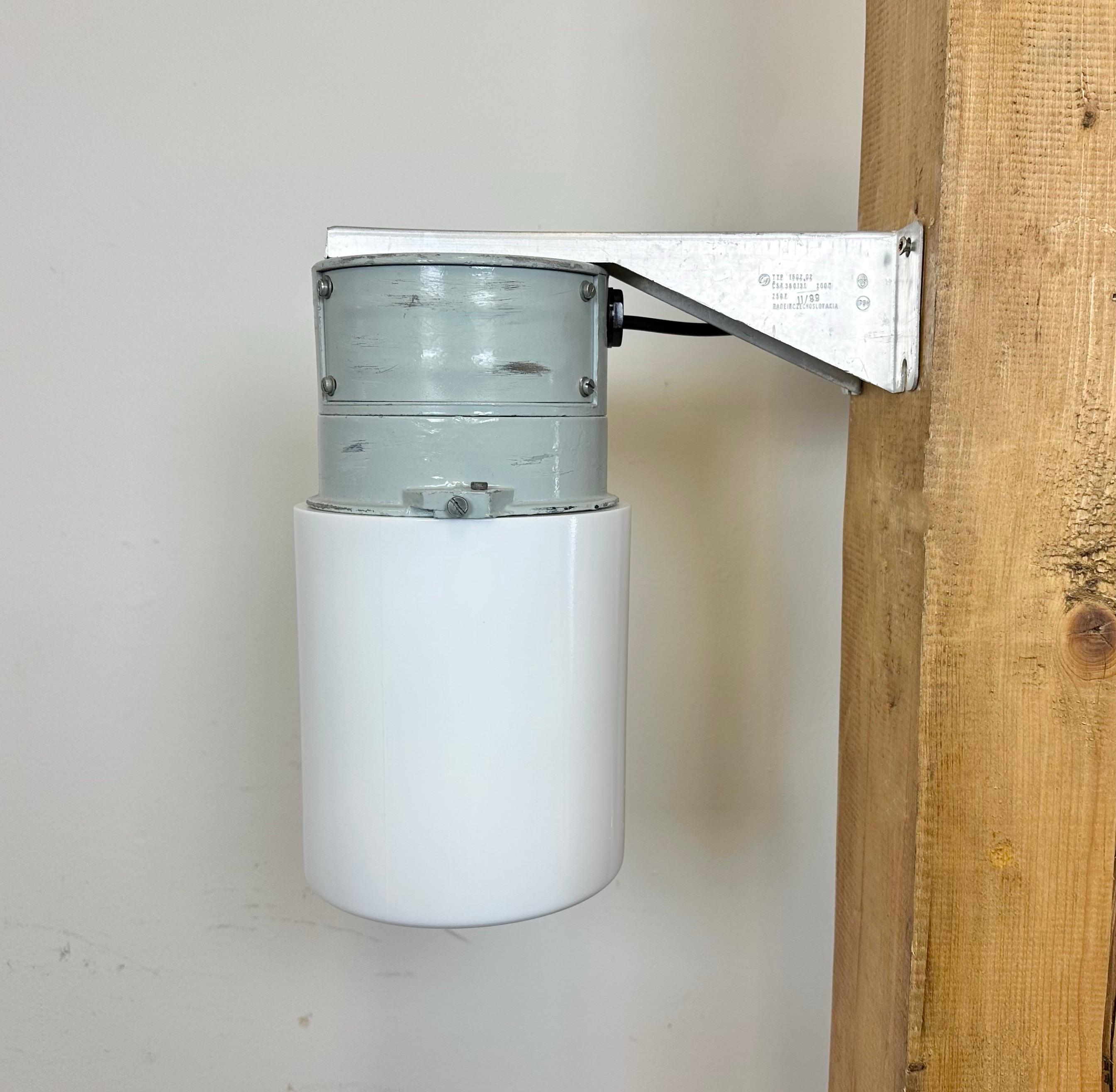 This Industrial wall light was made by Elektrosvit in former Czechoslovakia during the 1970s. It features a cast aluminium wall mounting and a milk glass cover. New porcelain socket requires standard E 27/ E26 light bulbs. New wire. The weight of