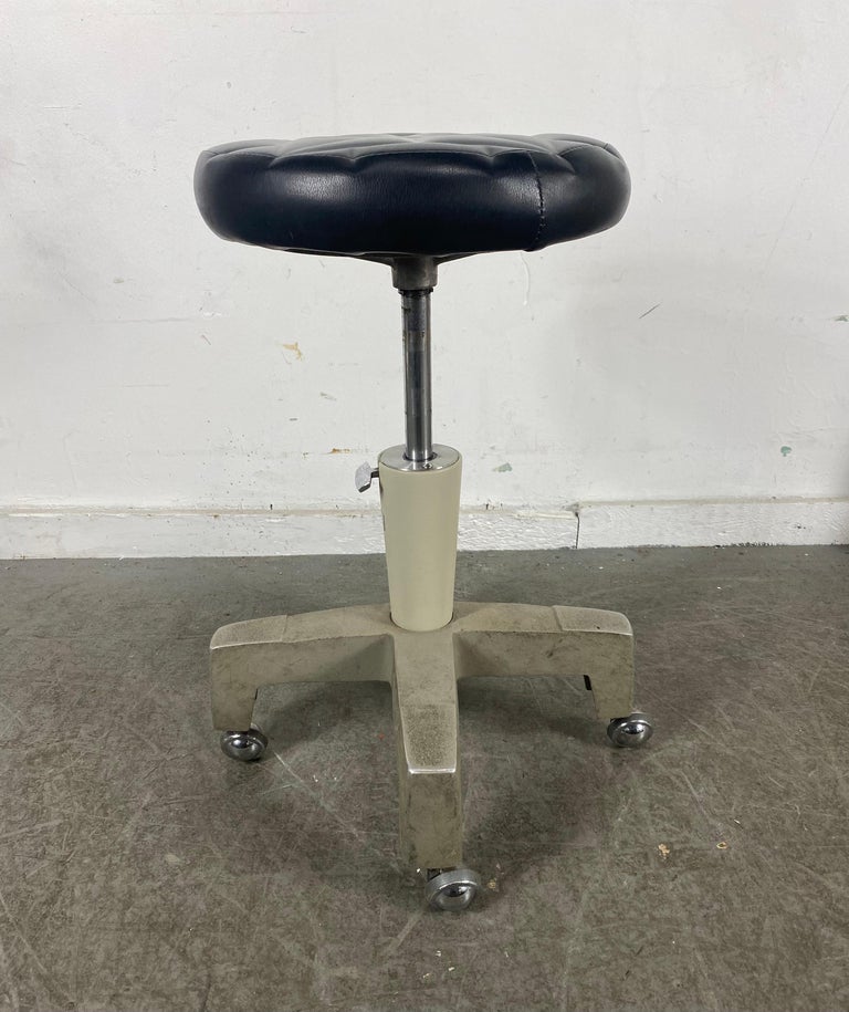 Stylized Industrial, midcentury, medical, dentist stool with tufted seat., 13 inch diameter, faux leather seat is height adjustable from 18-27 inches.