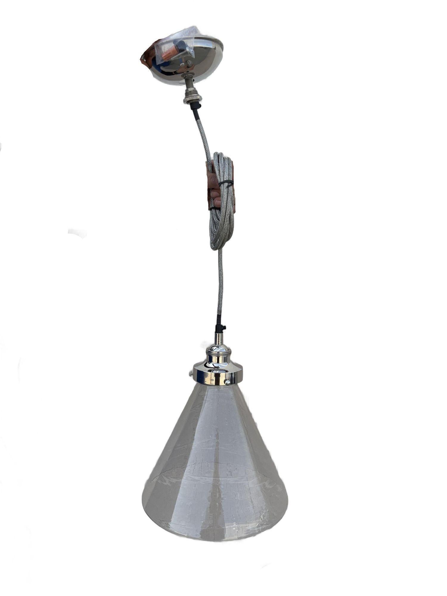 Lampada industriale moderna a sospensione da soffitto in alluminio con paralume a cono in vetro trasparente. Il paralume in vetro soffiato trasparente con una sottile finitura strutturata e un elegante design conico, è completato da un attacco in