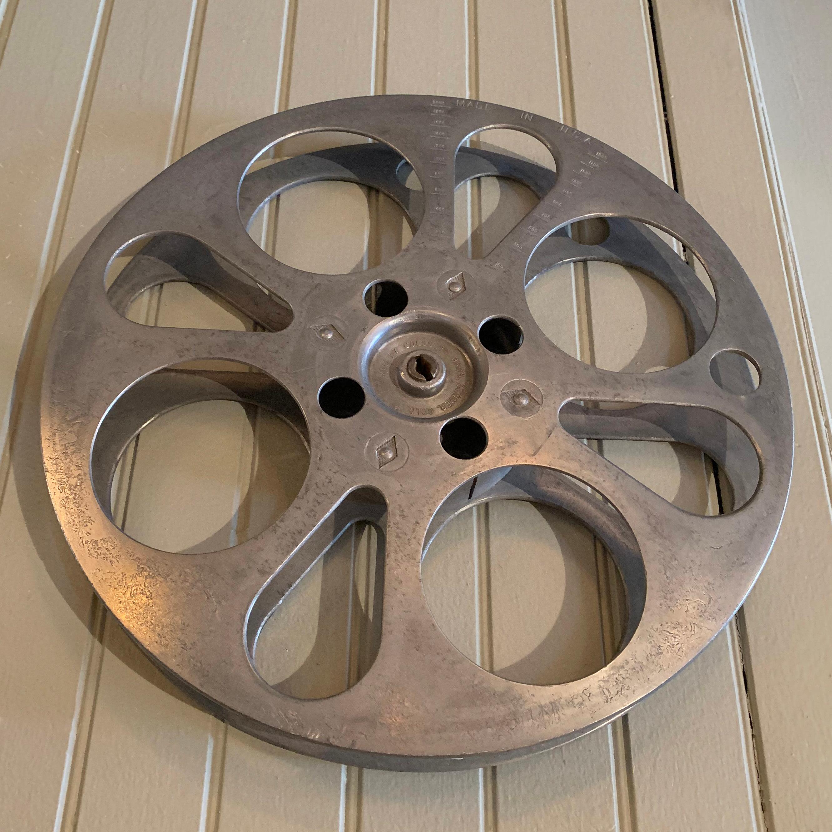 Industrial, midcentury, film reel is a great accent piece or wall hanging.
