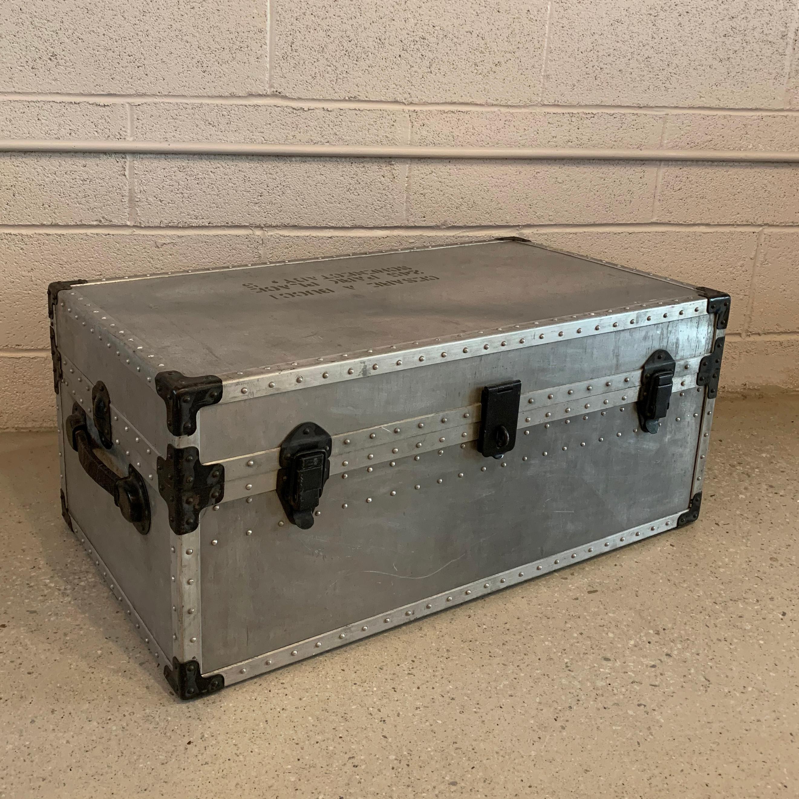Industrial, aluminum, military trunk features black steel hardware and reinforced edges and leather side handles.
