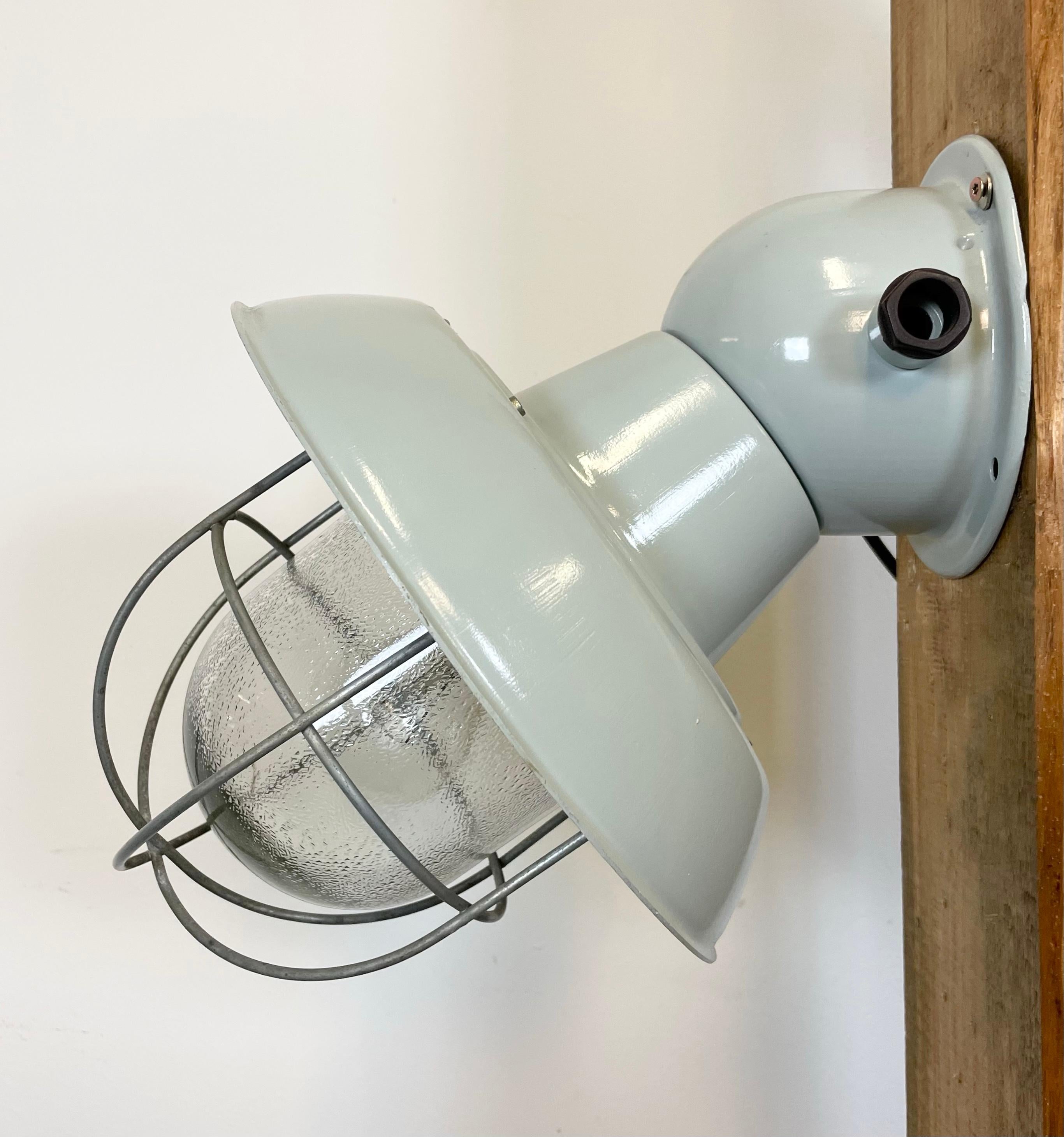 Industrial wall lamp made in former Czechoslovaki during the 1960s.It features an aluminium shade , an iron wall mounting, a frosted glass and iron grid.
New porcelain socket requires E 27 light bulbs. New wire. The weight of the lamp is 3 kg. The