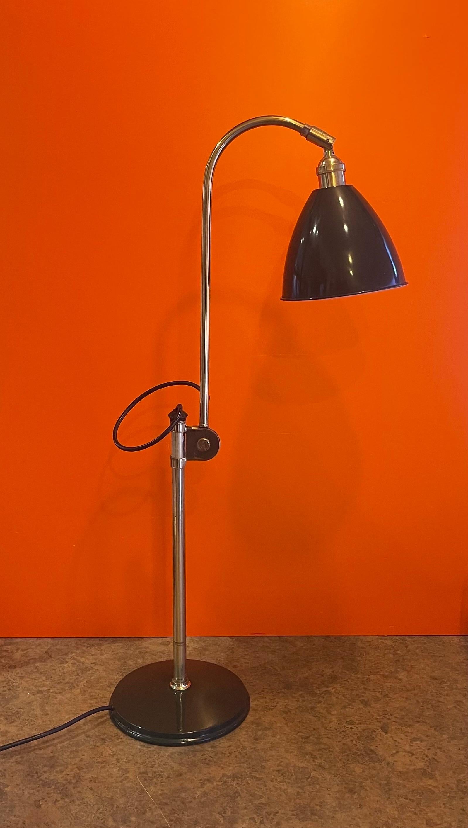 A very cool architectural drawing desk lamp by Louis Baldinger, circa 1980s. The piece is in good vintage condition and made of green painted sheet metal with brass accents and bars. The lamp is fully articulated at lamp hood and center of stem and