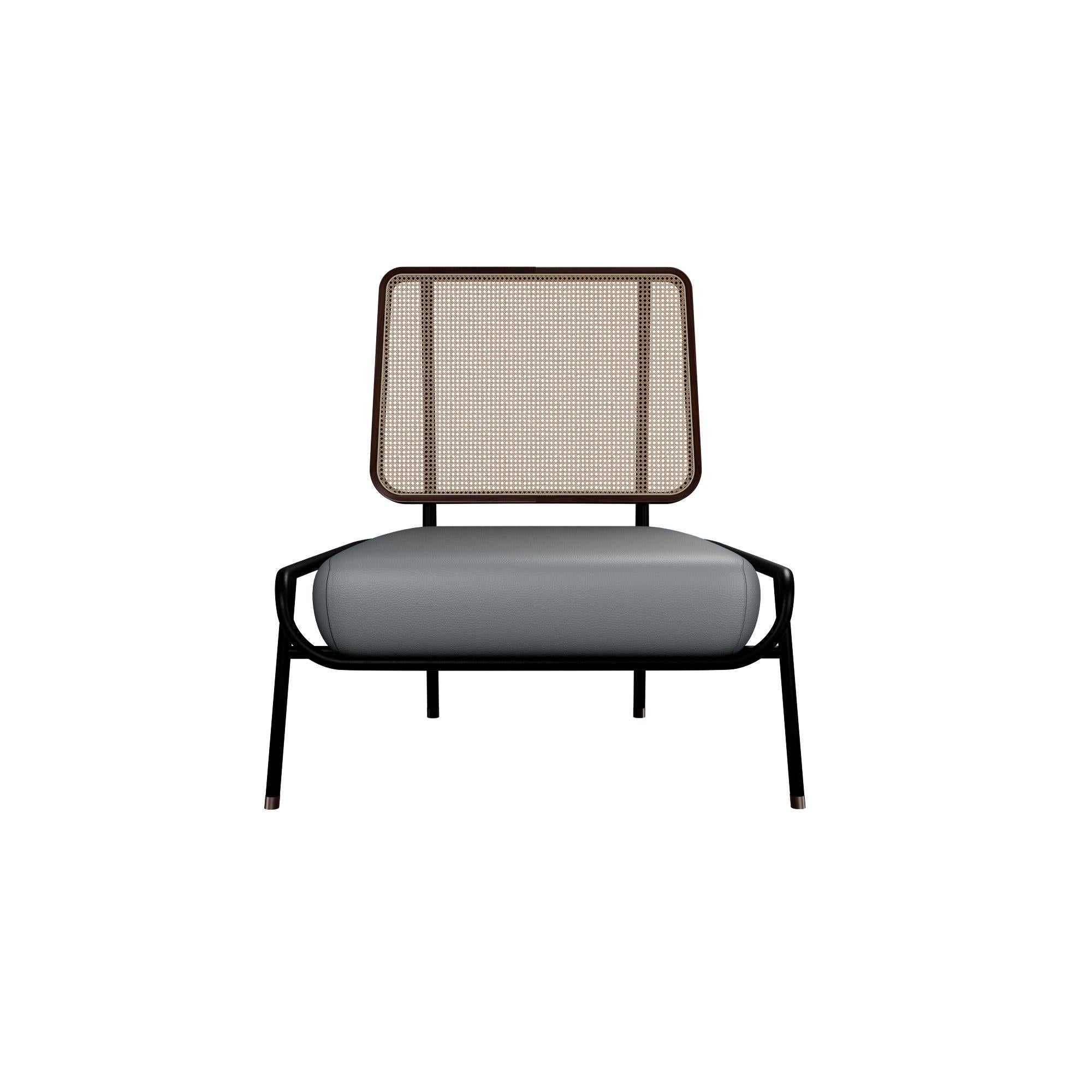 Murmurio's armchair without arms DUV sturdy iron structure provides a solid foundation, while the intricately woven rattan backrest, supported by an ashwood frame, adds a touch of natural beauty. The seat is upholstered in genuine leather, offering
