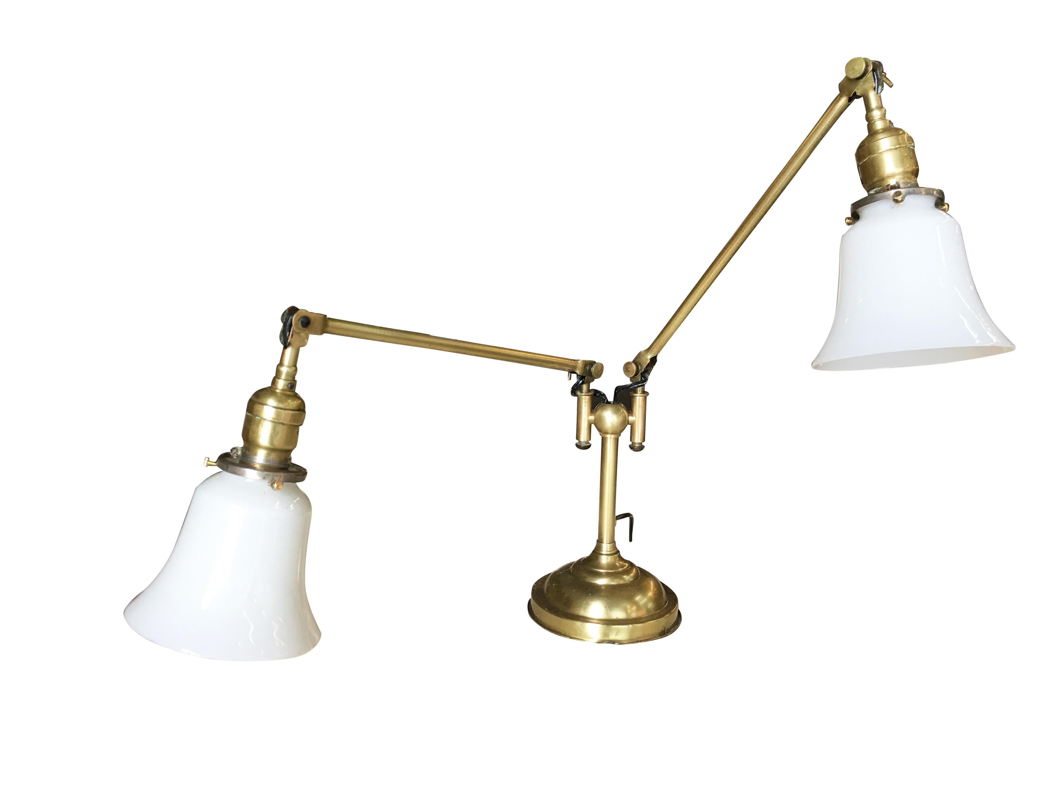Early late Edwardian industrial articulating brass lamp with dual lights. Each with milk glass bell-shaped shades. The lamp is in excellent condition and works perfectly.

Dimensions:
21