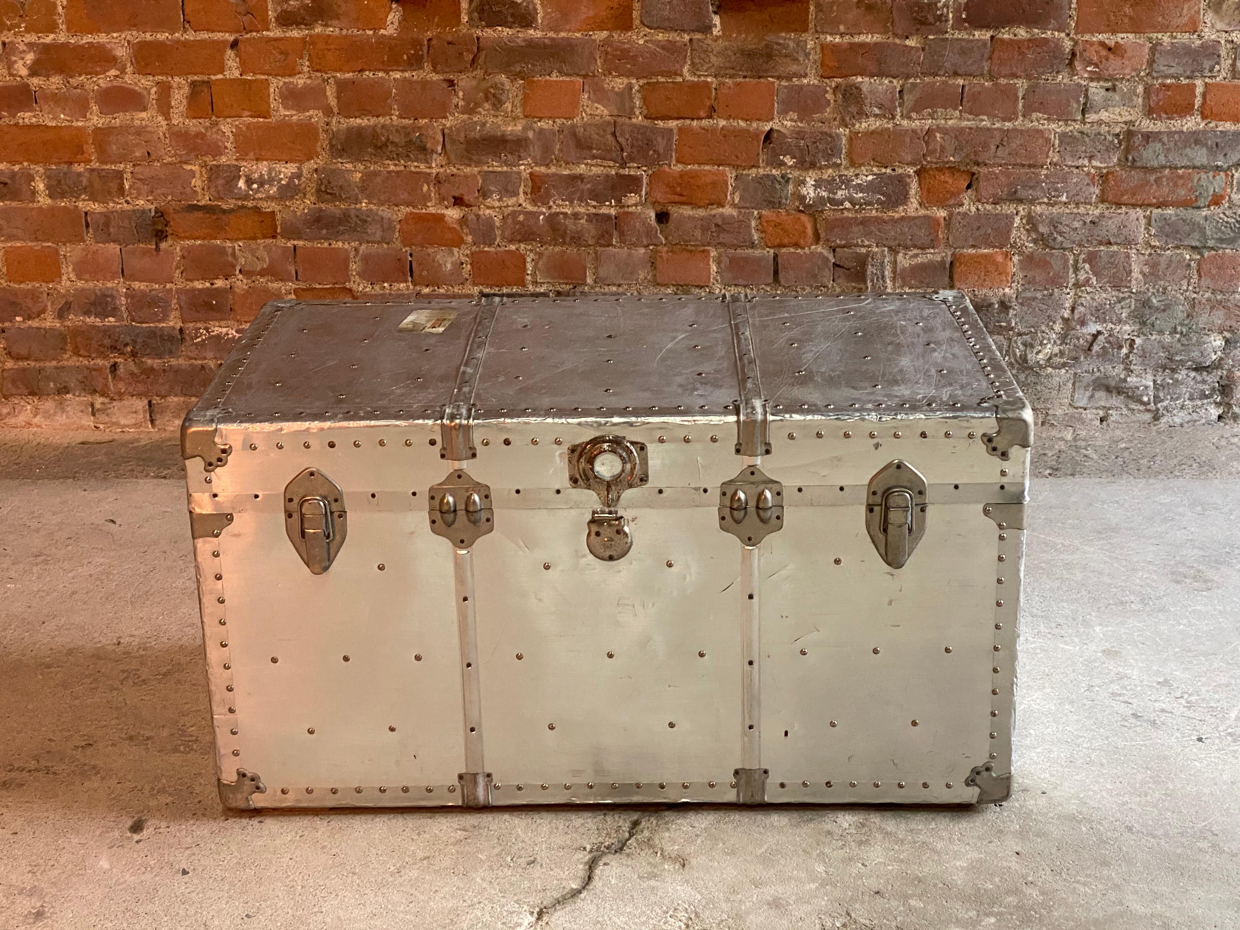 Industrial aviation aluminium travel trunk coffee table circa 1940

Industrial aviation aluminium travel trunk circa 1940, a genuine travelling trunk with hinged lid, the trunk having studded outline and heavy locks and clasps, riveted all-over