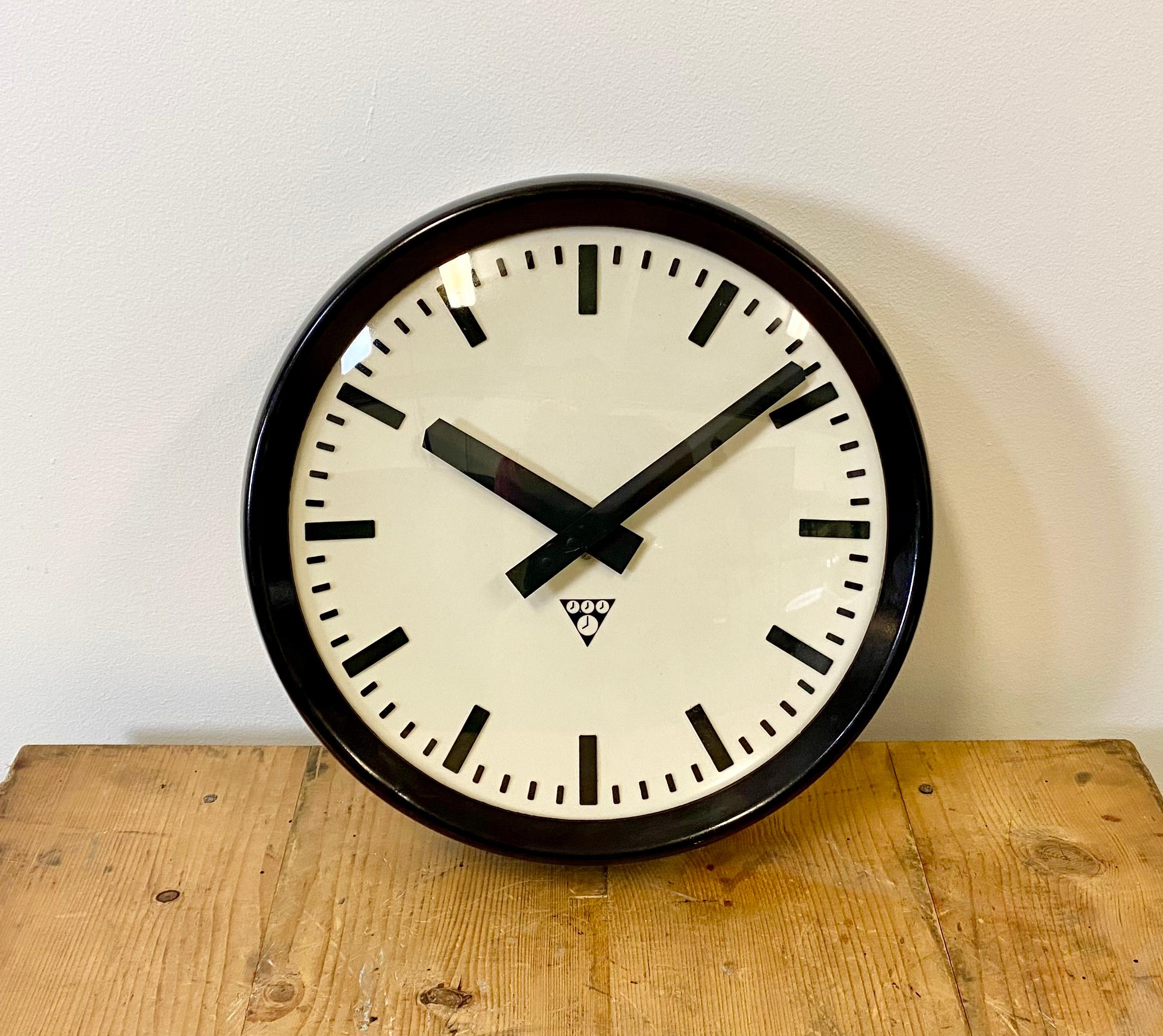 This wall clock was produced by Pragotron in former Czechoslovakia during the 1960s. The piece features a brown Bakelite frame, white Bakelite dial, aluminum hands and a curved clear glass cover. The piece has been converted into a battery-powered