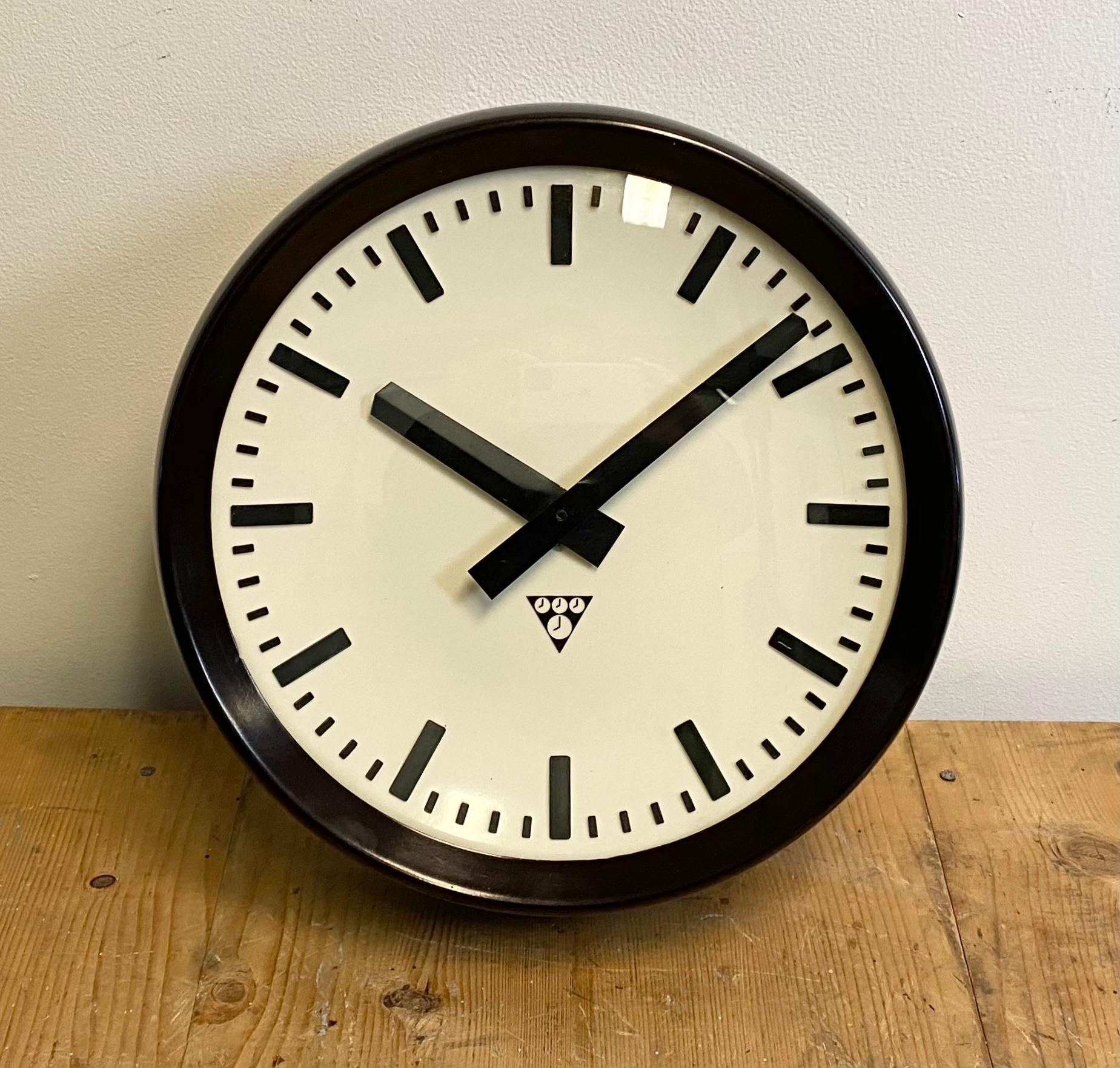 This wall clock was produced by Pragotron in former Czechoslovakia during the 1960s. The piece features a brown Bakelite frame, white Bakelite dial, aluminum hands and a curved clear glass cover. The piece has been converted into a battery-powered