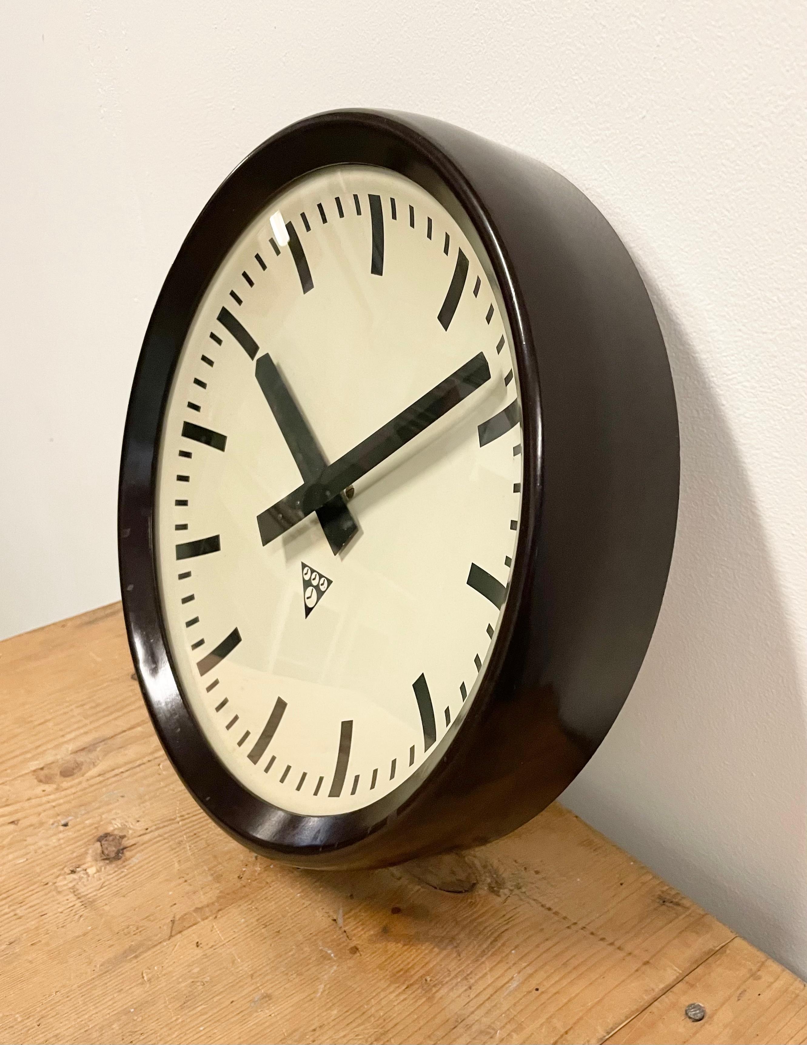 This wall clock was produced by Pragotron in former Czechoslovakia during the 1960s. The piece features a brown bakelite frame, aluminium dial and a clear glass cover. The piece has been converted into a battery-powered clockwork and requires only