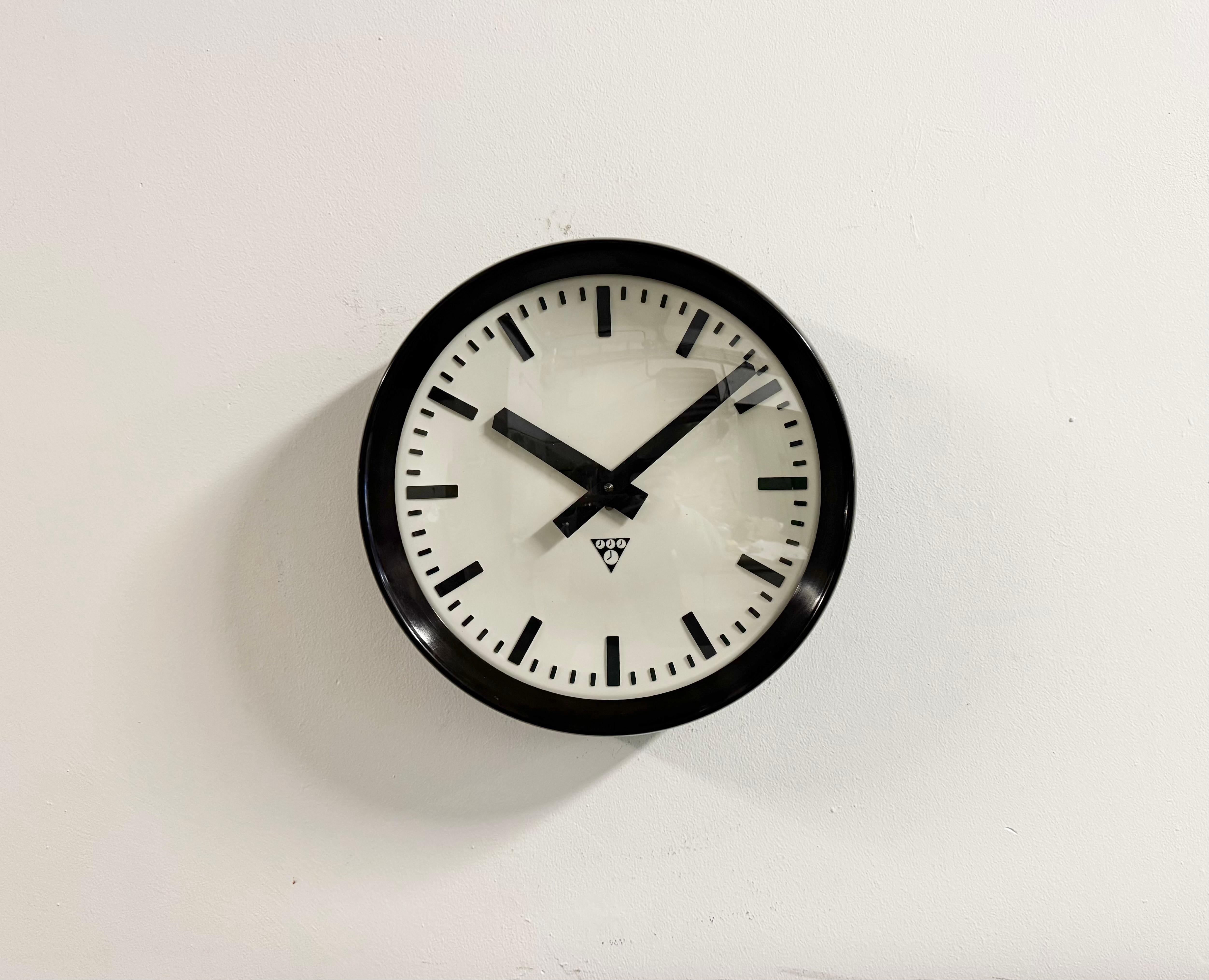 This wall clock was produced by Pragotron in former Czechoslovakia during the 1960s. It features a brown bakelite frame, a plastic dial, an aluminium hands and a  convex clear glass cover. The piece has been converted into a battery-powered