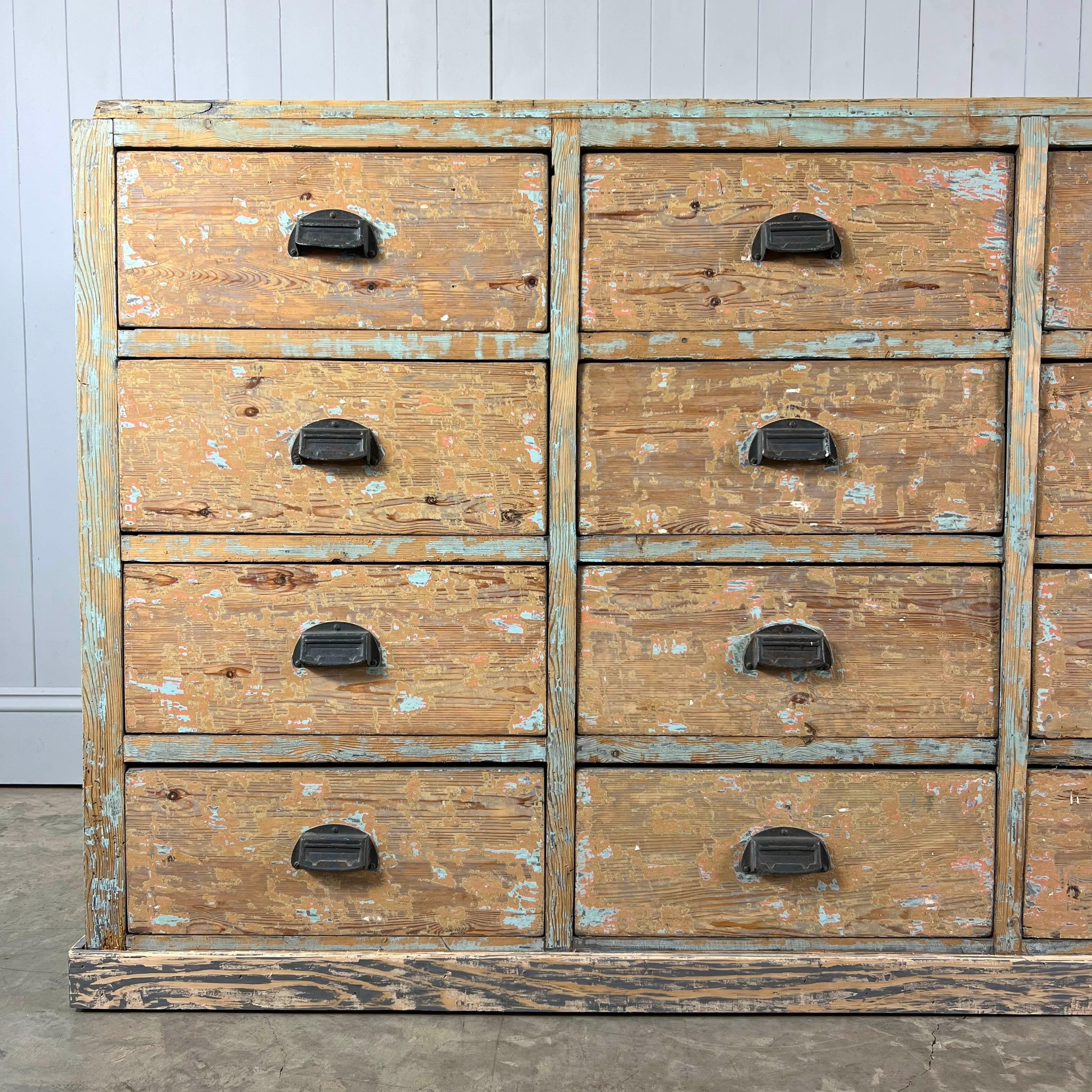 This huge antique bank of drawers was sourced from a factory in Avignon, South of France, circa 1900-1920. It has 20 drawers in total! 

It has a few bumps and knocks but is generally in good clean and sturdy condition. circa 1900-1920 this