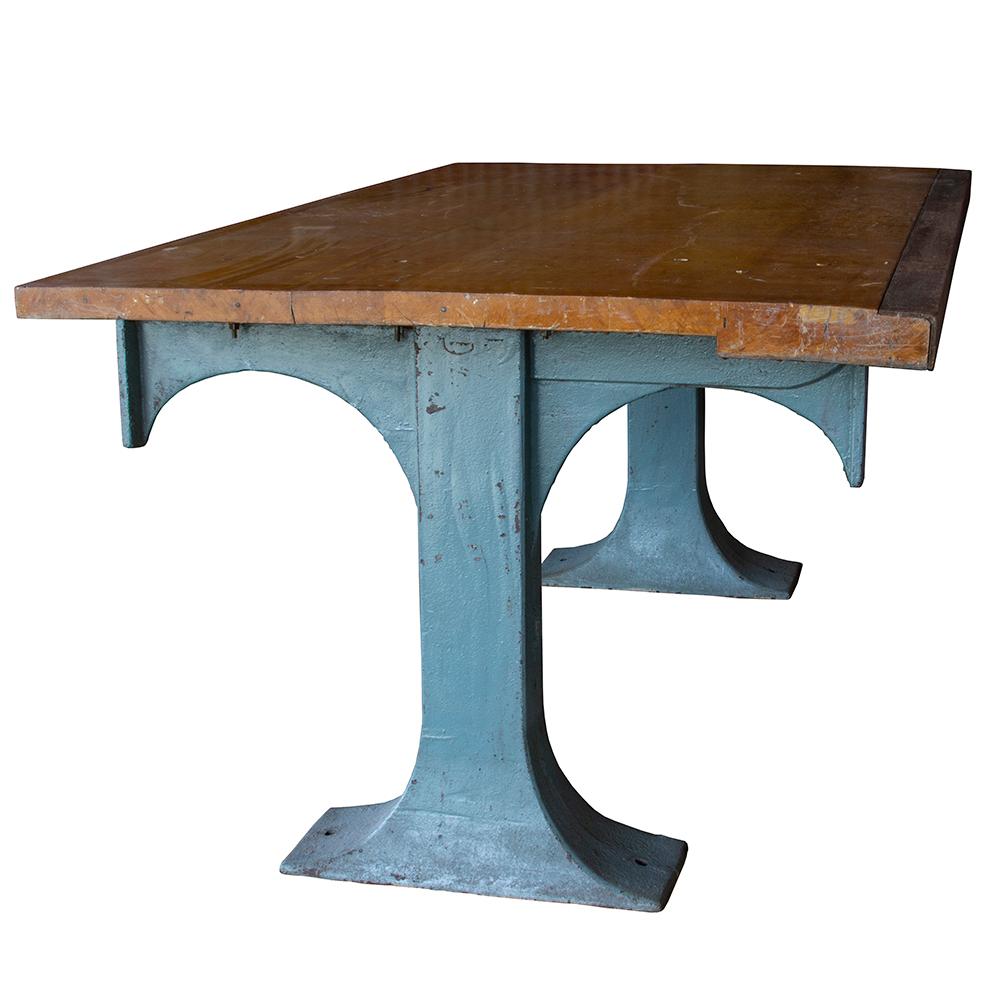 This table features a marriage of hefty cast iron industrial legs with a maple top. The top has a steel edge on one side and the delicate blue color is a nice contrast to the honey maple hue of the top.