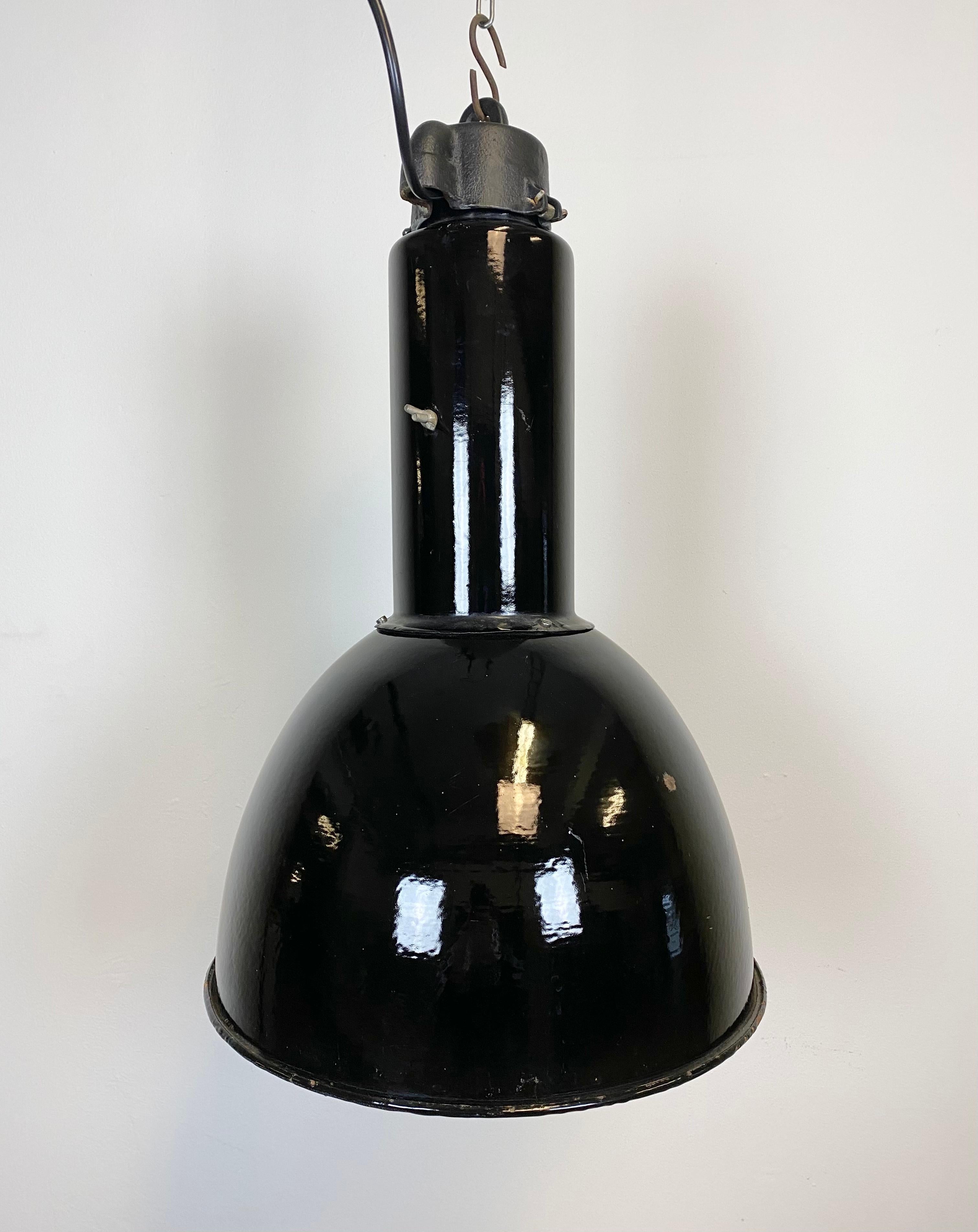 Industrial black enamel pendant lamp made by Elektrosvit in former Czechoslovakia. Designed in the period of Bauhaus. White enamel inside the shade. Cast iron top. New porcelain socket for E 27 lightbulbs and wire. Fully functional. The weight of