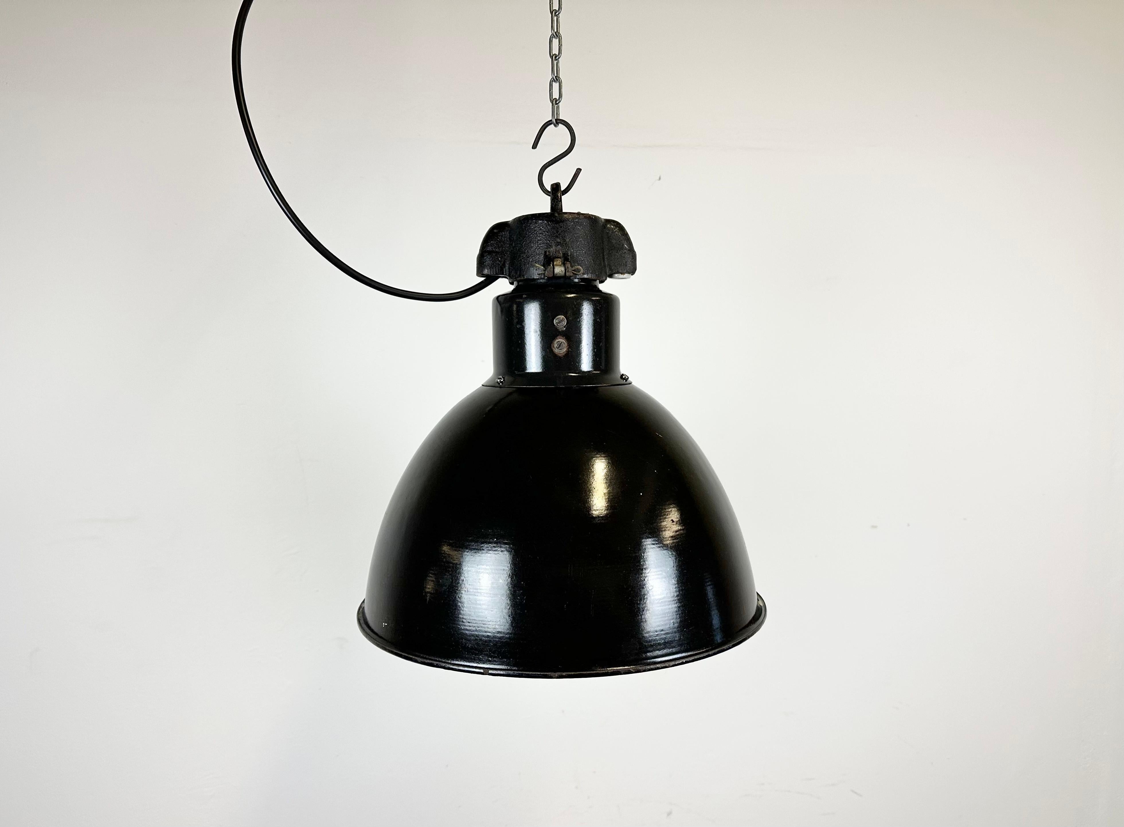 Industrial black enamel pendant light made by Elektrosvit in former Czechoslovakia. Designed in the period of Bauhaus. White enamel inside the shade. Cast iron top. New porcelain socket for E 27 lightbulbs and wire. Fully functional. The weight of