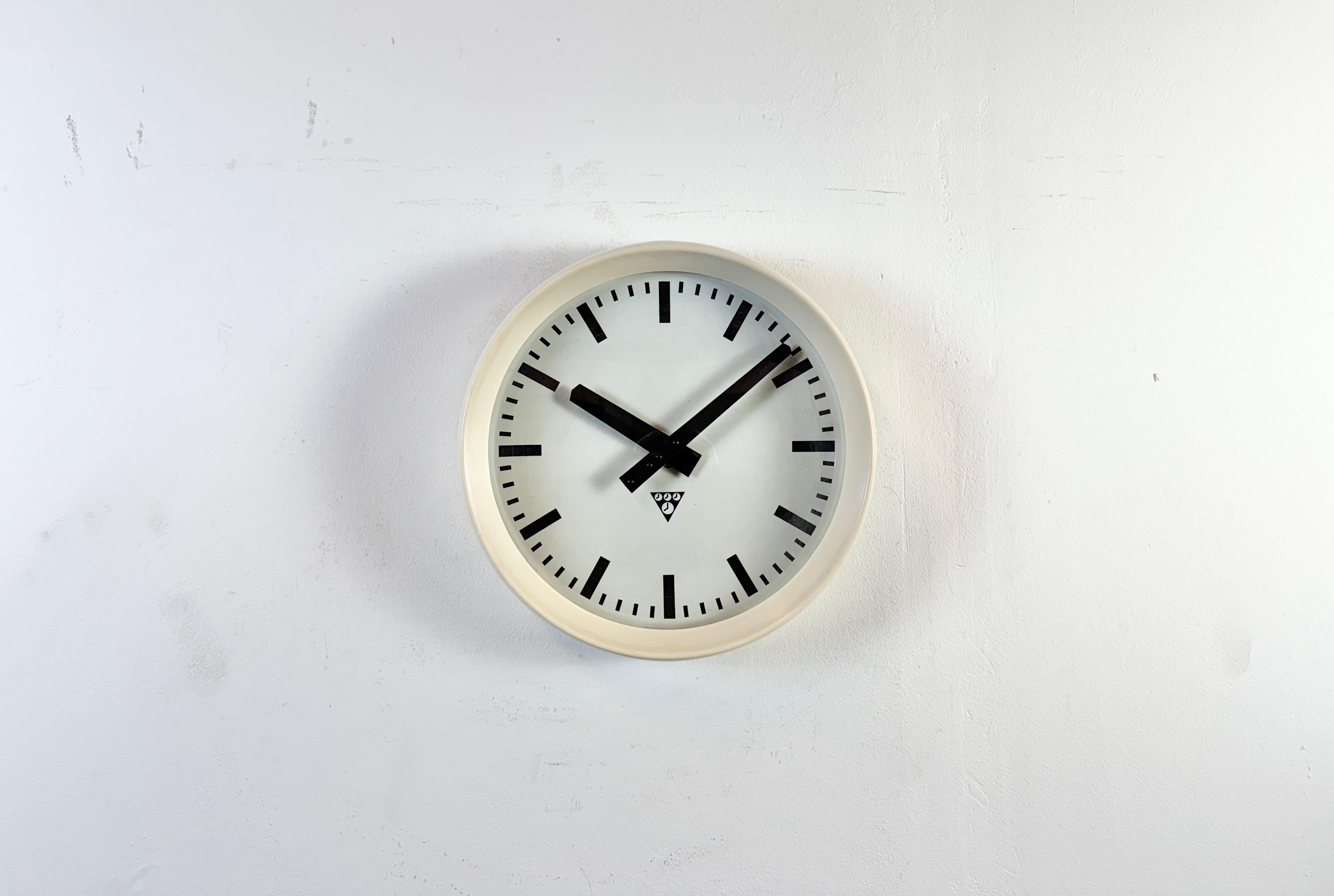 Este reloj de pared fue fabricado por Pragotron en la antigua Checoslovaquia durante la década de 1960. Tiene un marco de baquelita beige, una esfera de aluminio, manecillas y una tapa de cristal transparente convexo. La pieza se ha convertido en un