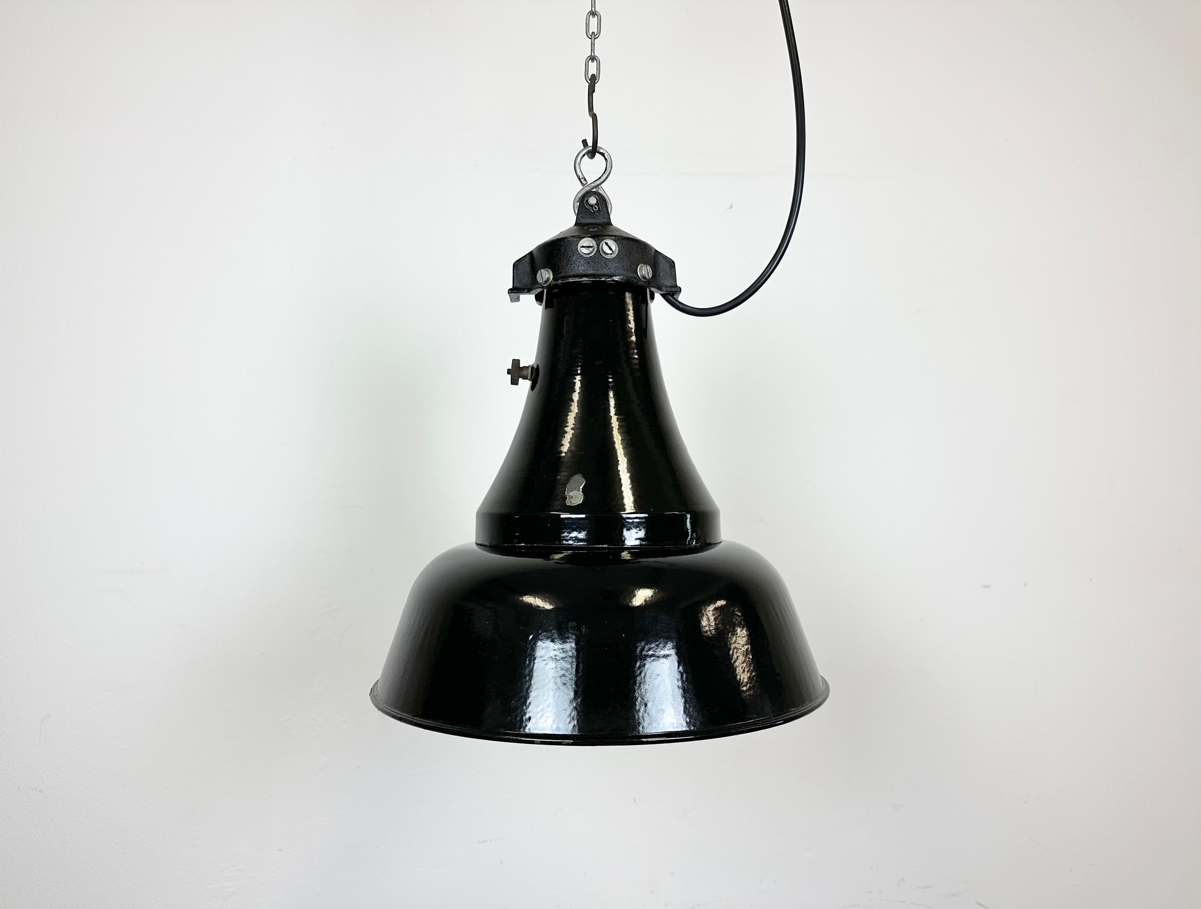 Vintage Industrial black enamel pendant lamp in Bauhaus style. Used in factories in former Czechoslovakia during the 1930s. White enamel interior. Cast iron top.The socket requires E27/ E26 lightbulbs.New wire. Measures: Lampshade diameter 32 cm.