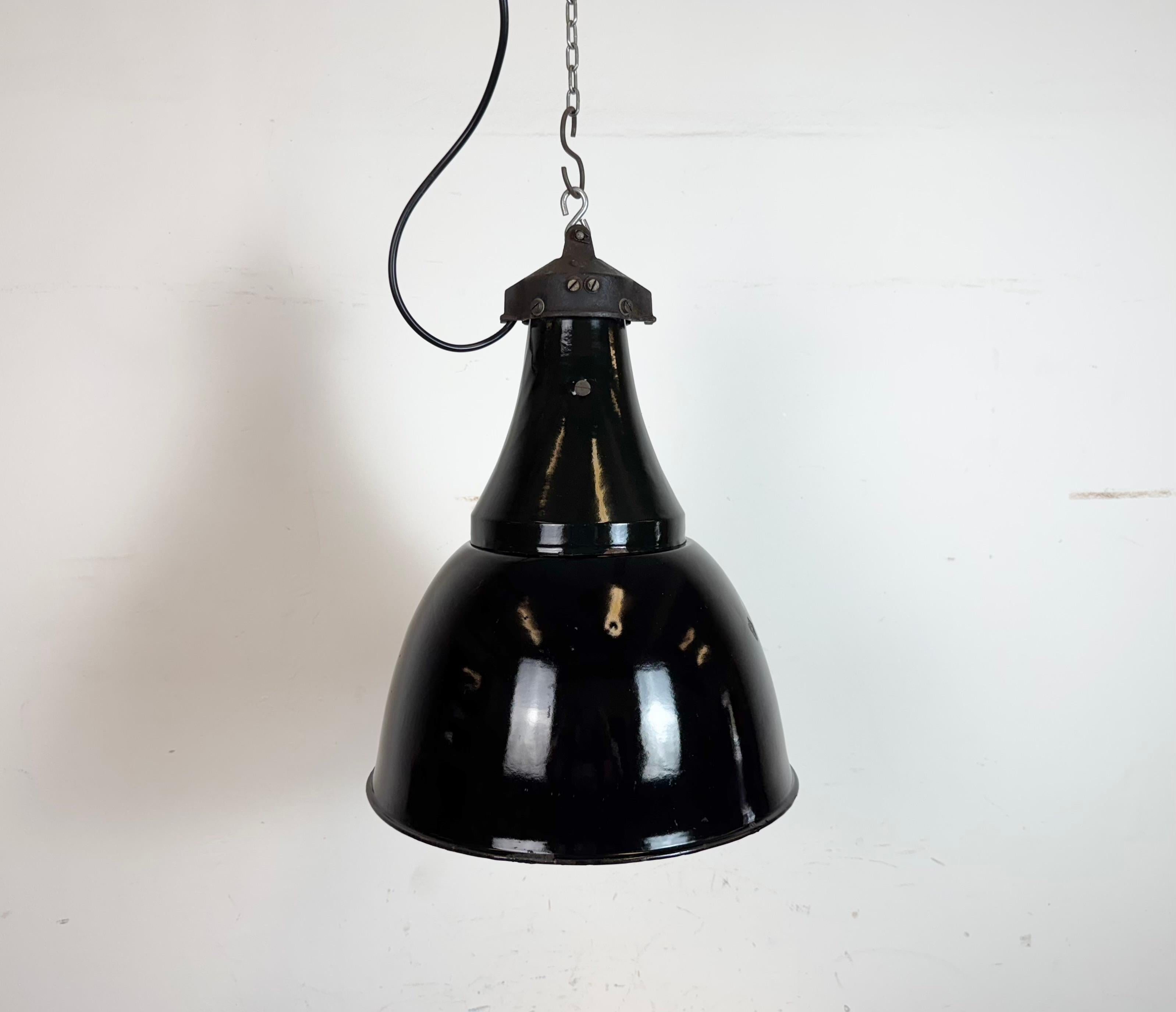 Lampe suspendue vintage industrielle en émail noir dans le style Bauhaus. Utilisé dans les usines de l'ancienne Tchécoslovaquie dans les années 1930. Intérieur en émail blanc. Dessus en fonte. La nouvelle douille en porcelaine est compatible avec