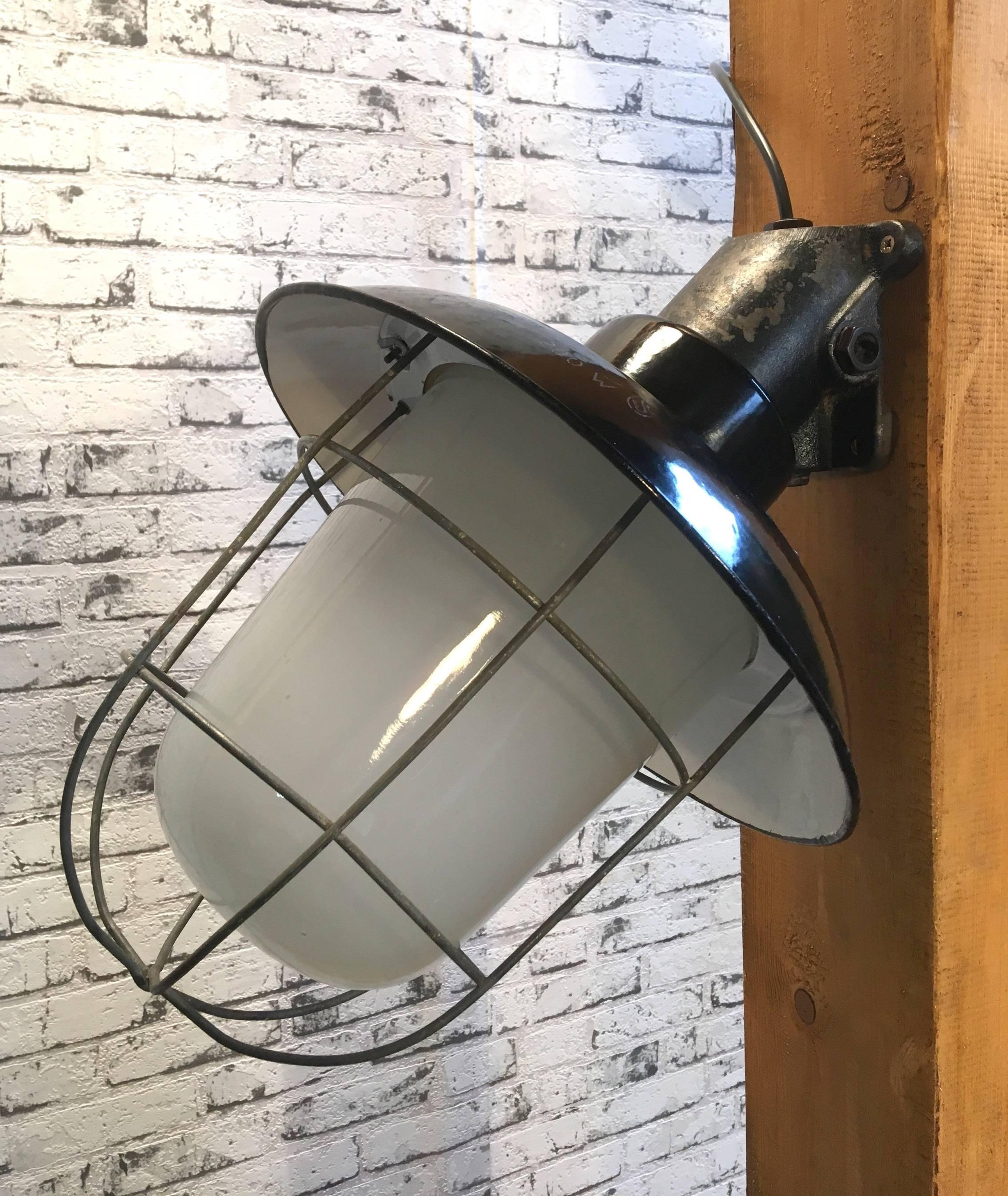 Industrial wall lamp. Cast iron arm. Black enamel shade. White interior. Milk glass. Iron grid.
New porcelain socket for E27 lightbulbs. New wire. Weight: 5.0 kg
Measures: Height 34.0 cm
Depth 45.0 cm
Diameter 35 cm.